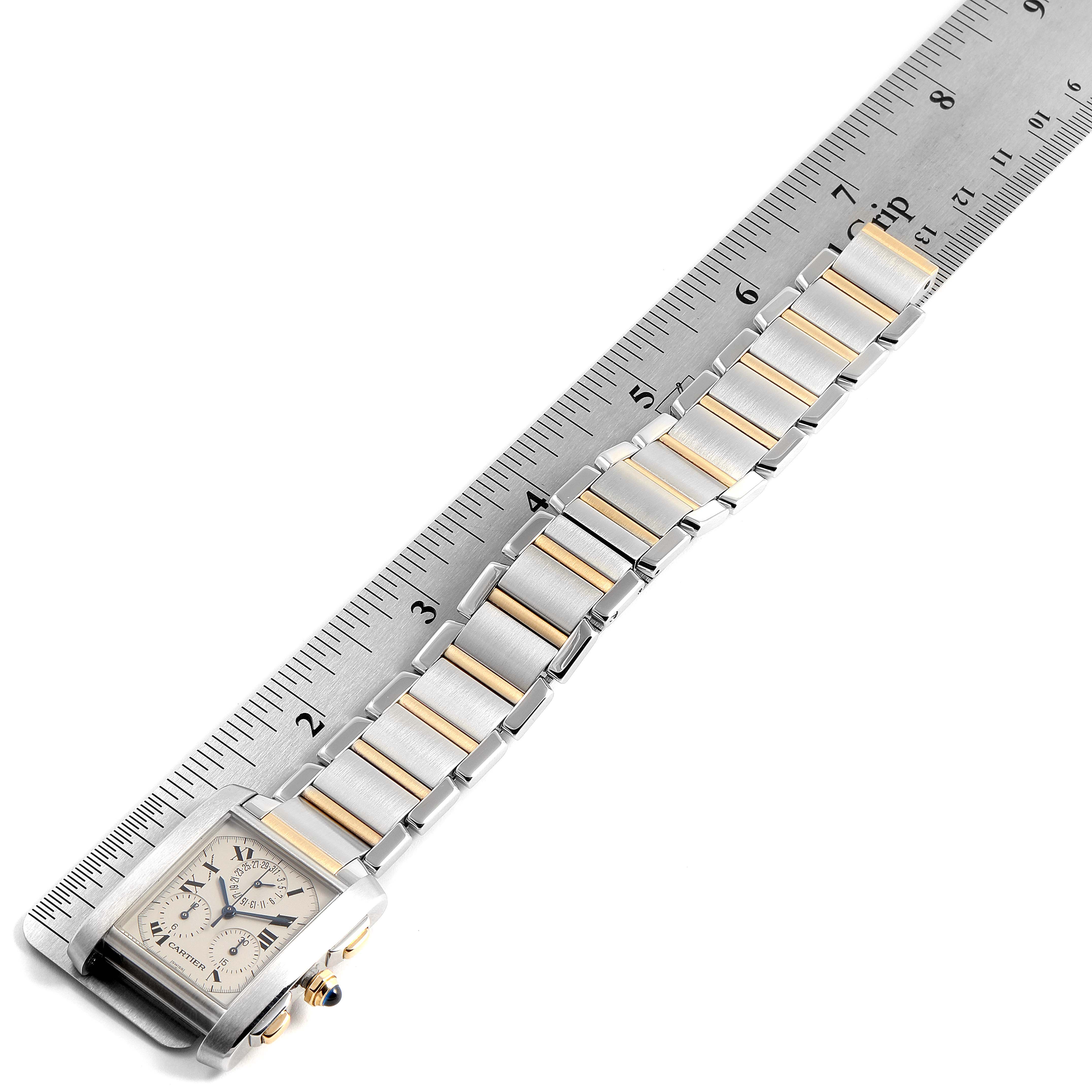 The Cartier Tank Francaise W51004Q4 Men's Steel and Gold (two tone) Silver Dial W51004Q4 Men's Steel and Gold (two tone) Silver Dial watch is shown from a top-down angle, highlighting its face, crown, and bracelet along a ruler.