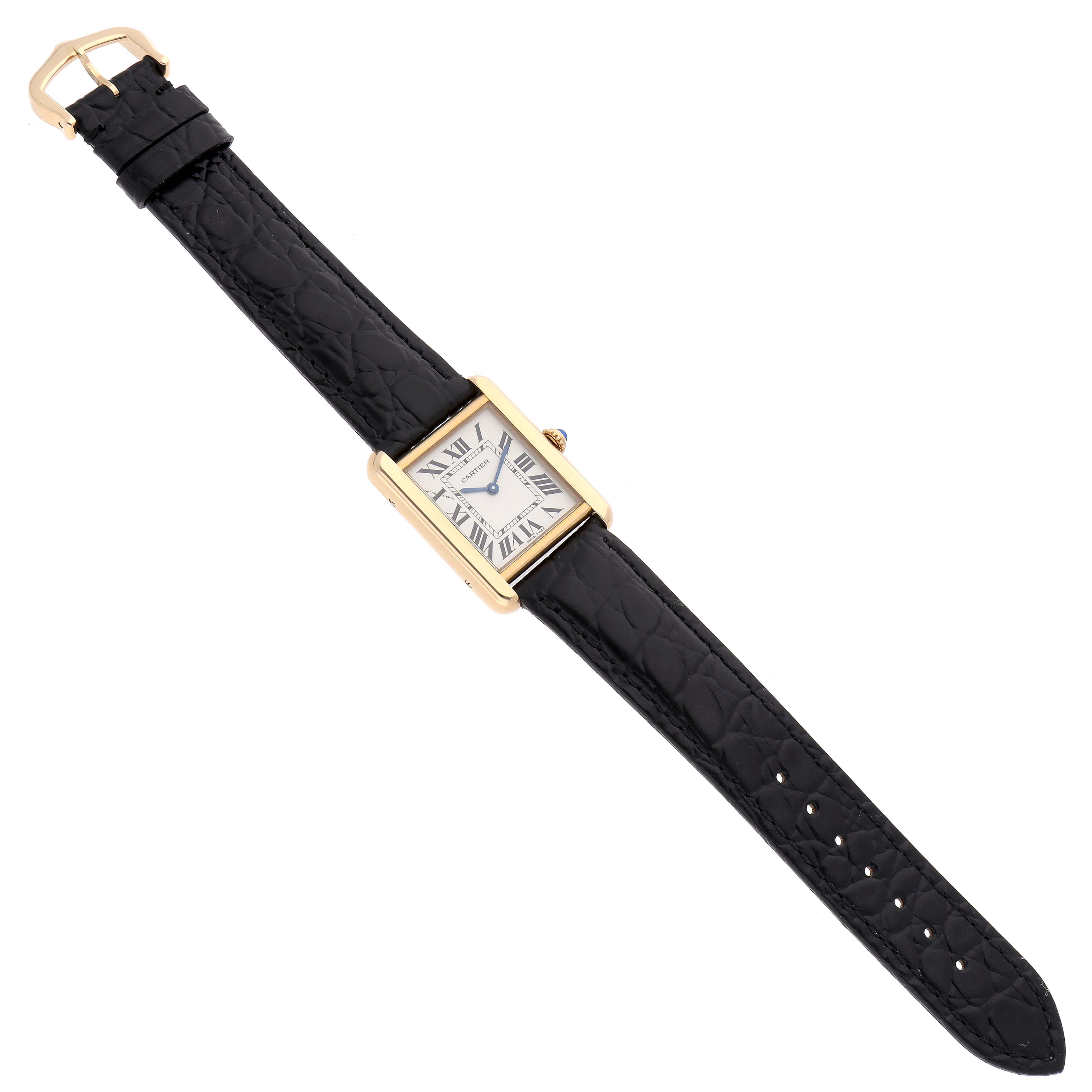 The Cartier Tank Solo W5200002 Women
s Yellow Gold Black Dial watch is shown from a top-down angle, highlighting its rectangular face and black leather strap.