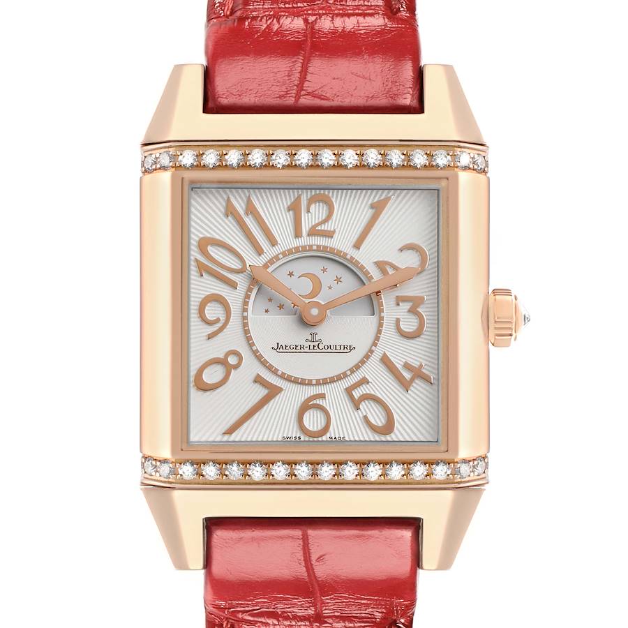 The image shows a front view of the Jaeger-LeCoultre Reverso watch, featuring its face, crown, and red leather strap.