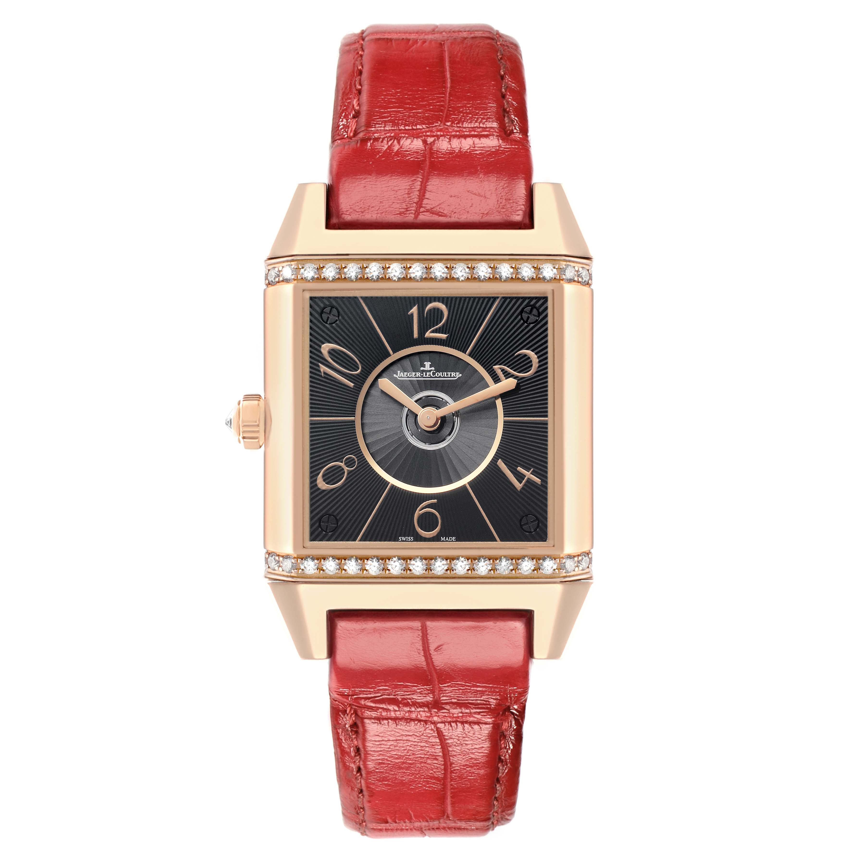 The Jaeger-LeCoultre Reverso watch is shown from the front, displaying its black dial, rose gold case, and red leather strap.