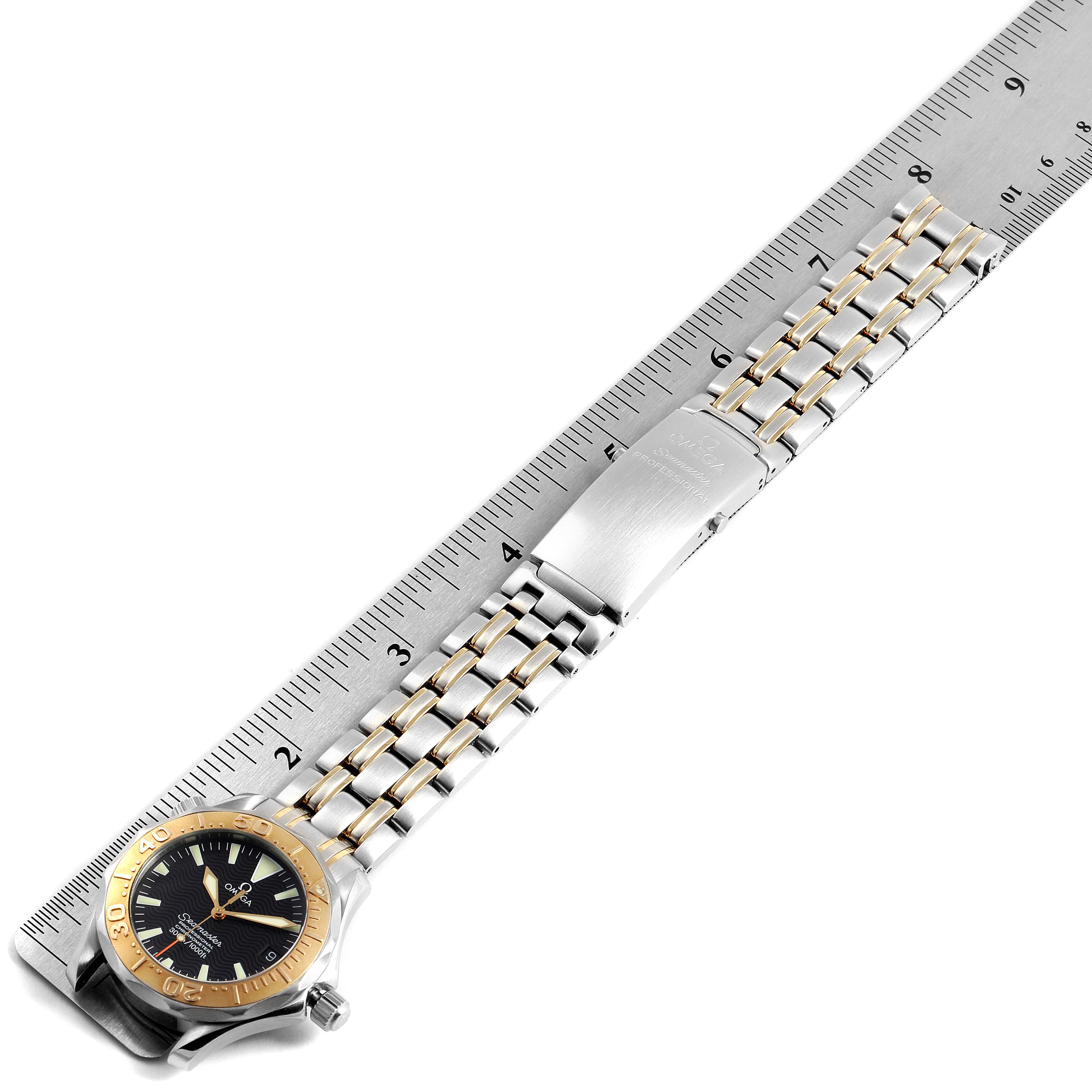 The Omega Seamaster 2453.50.00 Men's Steel and Gold (two tone) Black Dial 2453.50.00 Men's Steel and Gold (two tone) Black Dial watch is shown lying flat with its bracelet fully extended against a ruler.