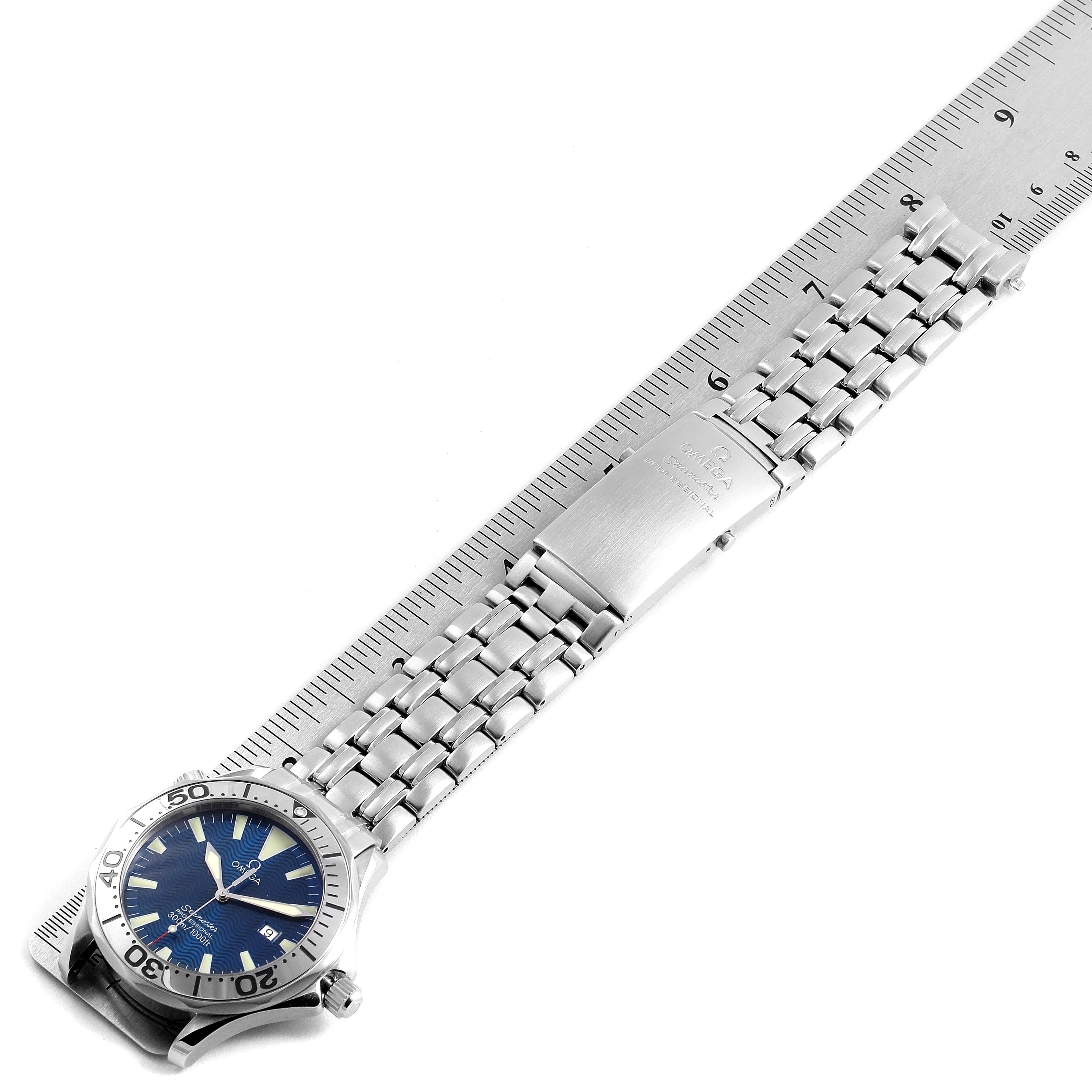 The Omega Seamaster 2265.80.00 Men
s Stainless Steel Blue Dial 2265.80.00 Men
s Stainless Steel Blue Dial watch is shown from a top-down angle, displaying its blue dial, bezel, bracelet, and clasp alongside a ruler for scale.