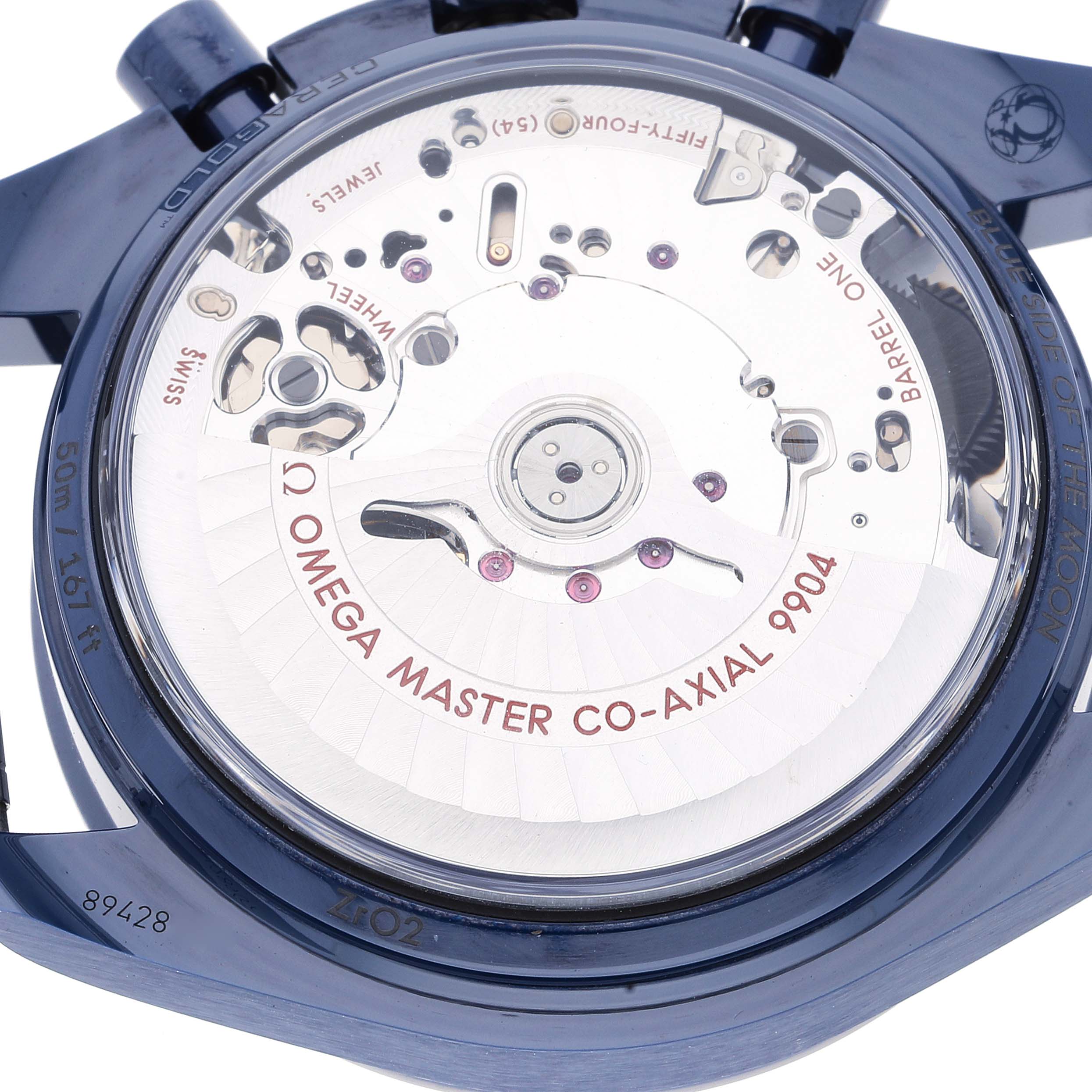 The image shows the back of an Omega Speedmaster 304.93.44.52.03.002 Men's Ceramic Blue Dial 304.93.44.52.03.002 Men's Ceramic Blue Dial watch, specifically the movement and "Omega Master Co-Axial 9904" text.