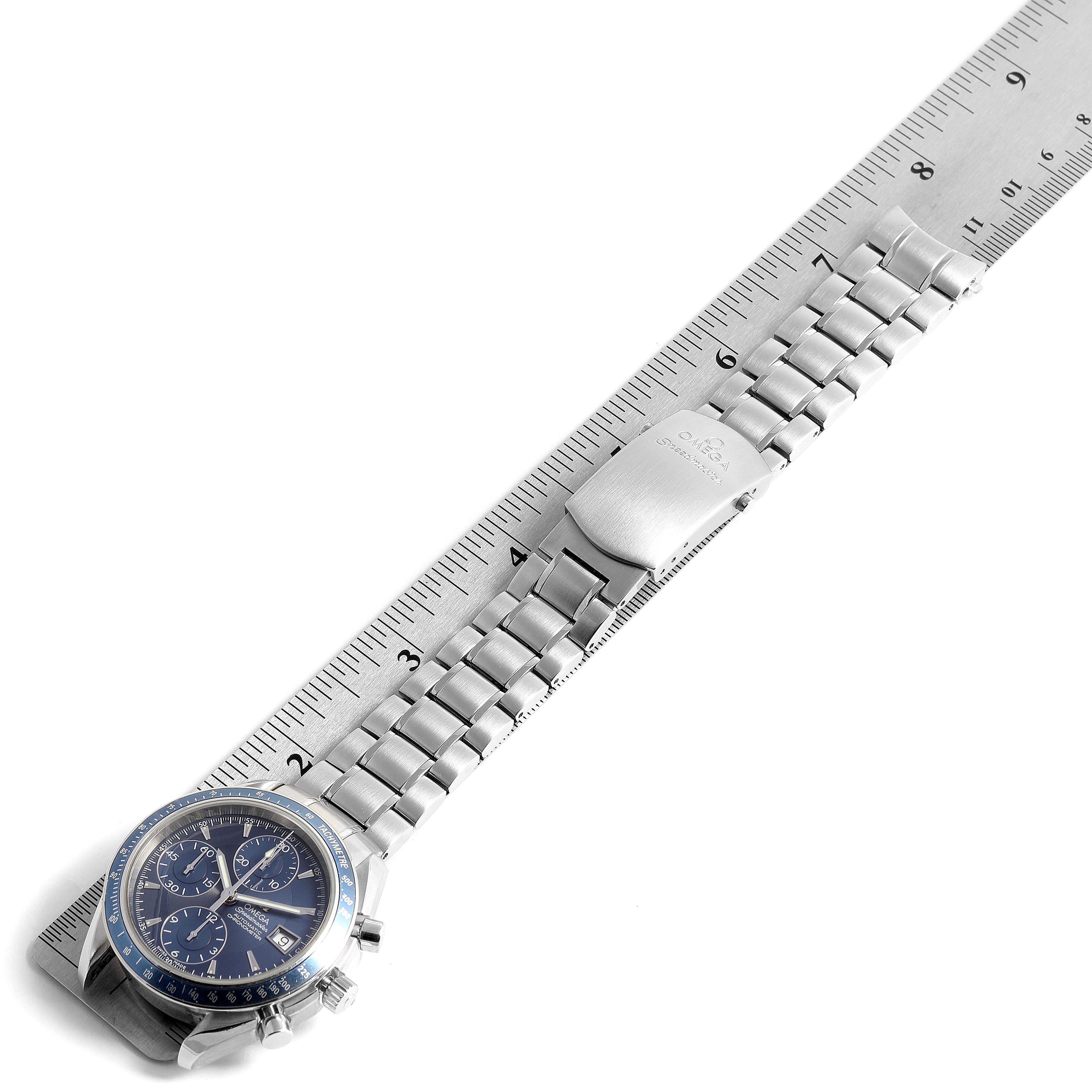 The Omega Speedmaster 3212.80.00 Men
s Stainless Steel Blue Dial 3212.80.00 Men
s Stainless Steel Blue Dial watch is shown from an overhead angle, displaying the dial and entire stainless steel bracelet next to a ruler.
