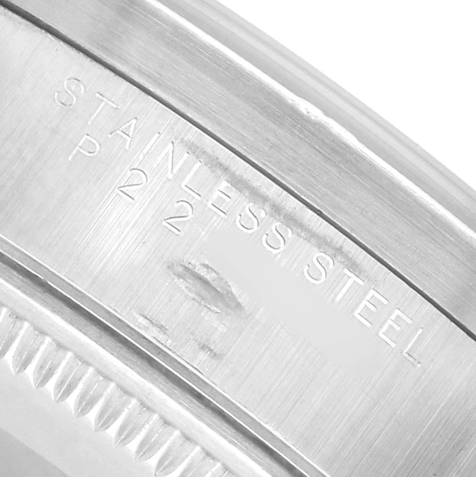 The image shows a close-up of the metal band, specifically the engravings, of a Rolex Air-King 14010 Men
s Stainless Steel Pink Dial watch.