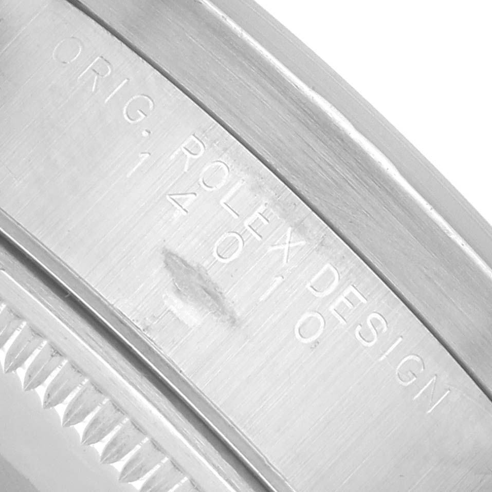 This image shows a close-up of the side engraving on a Rolex Air-King 14010 Men
s Stainless Steel Pink Dial watch, focusing on the "Rolex Design" text.