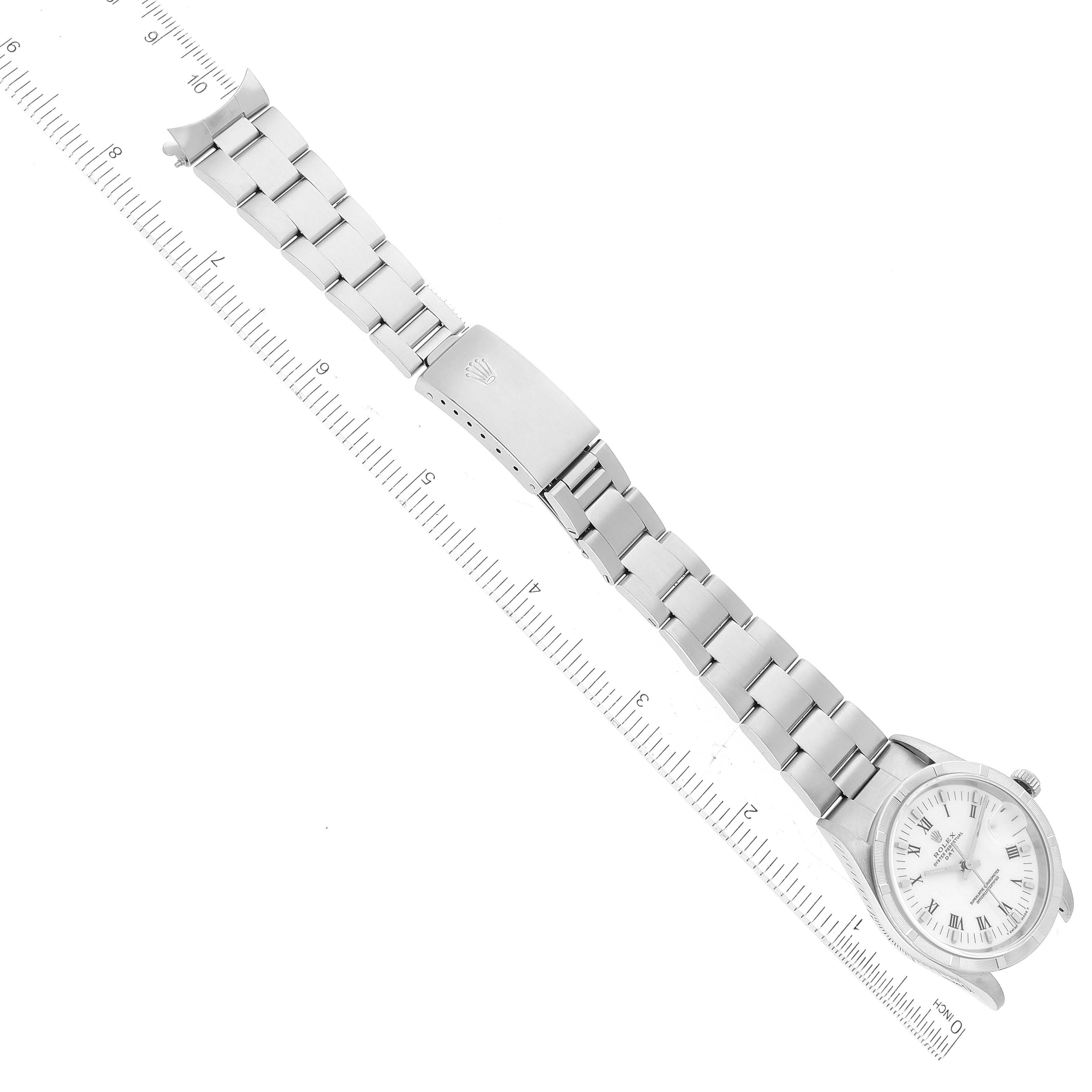 This top-down image shows the entire Rolex Date 15210 Men's Stainless Steel White Dial 15210 Men's Stainless Steel White Dial watch, including the dial, bracelet, and clasp, alongside a ruler for scale.