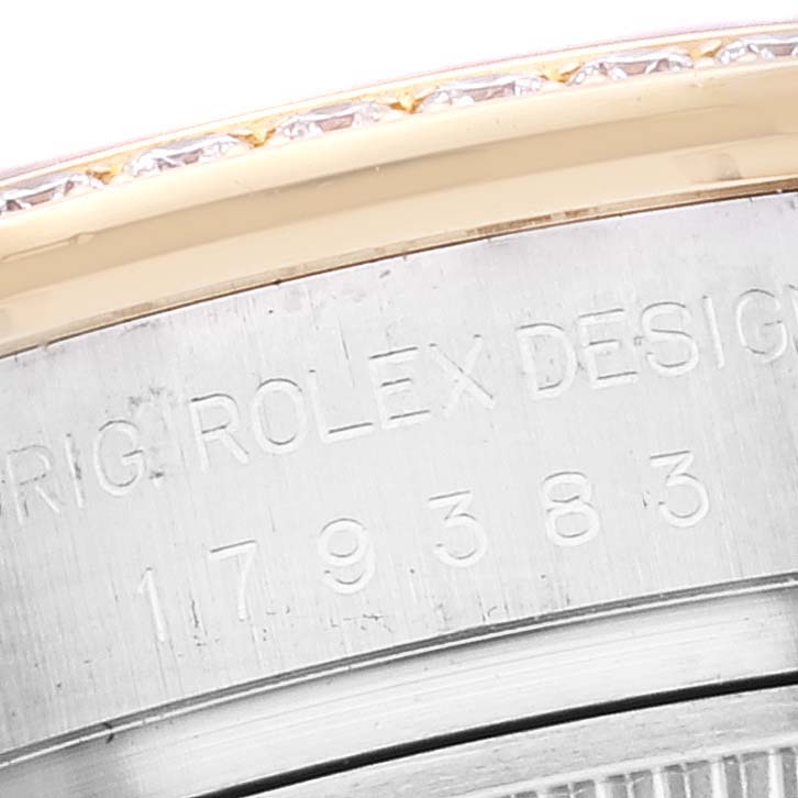 This image shows a close-up of the side of a Rolex Datejust 179383 Women's Steel and Gold (two tone) Mother of Pearl Dial 179383 Women's Steel and Gold (two tone) Mother of Pearl Dial watch, revealing part of the bezel and engraved serial number.