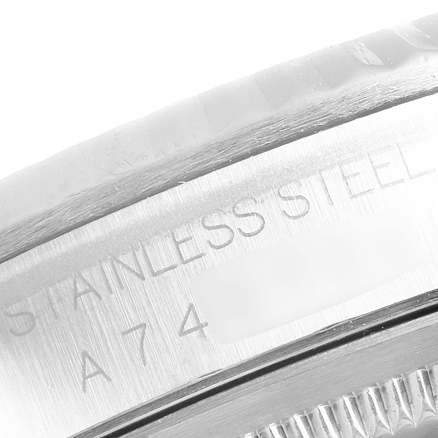 The image shows a close-up of the stainless steel bezel engraved with "STAINLESS STEEL" and partial serial number of a Rolex Datejust 16234 Men's Stainless Steel Blue Dial 16234 Men's Stainless Steel Blue Dial watch.