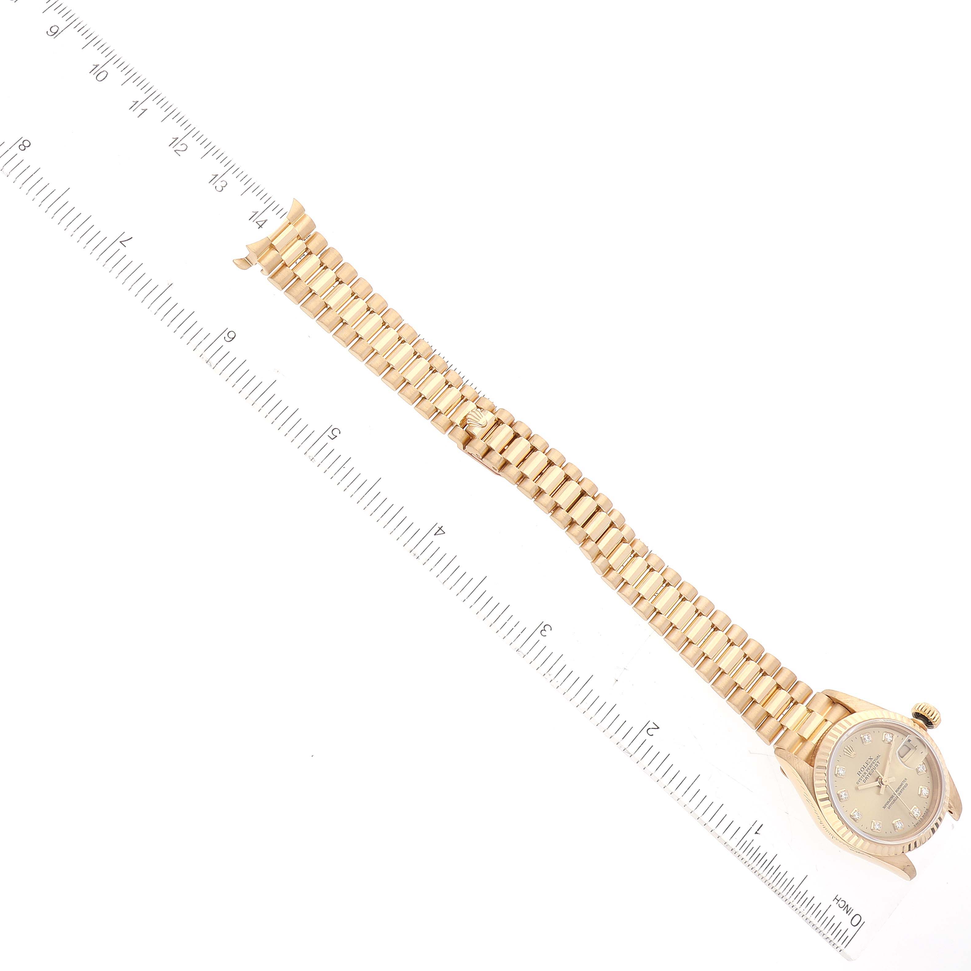 The image shows a Rolex President 69178 Women's Yellow Gold Champagne Dial 69178 Women's Yellow Gold Champagne Dial model watch taken from an angled top view, highlighting the watch's face and bracelet against a ruler.