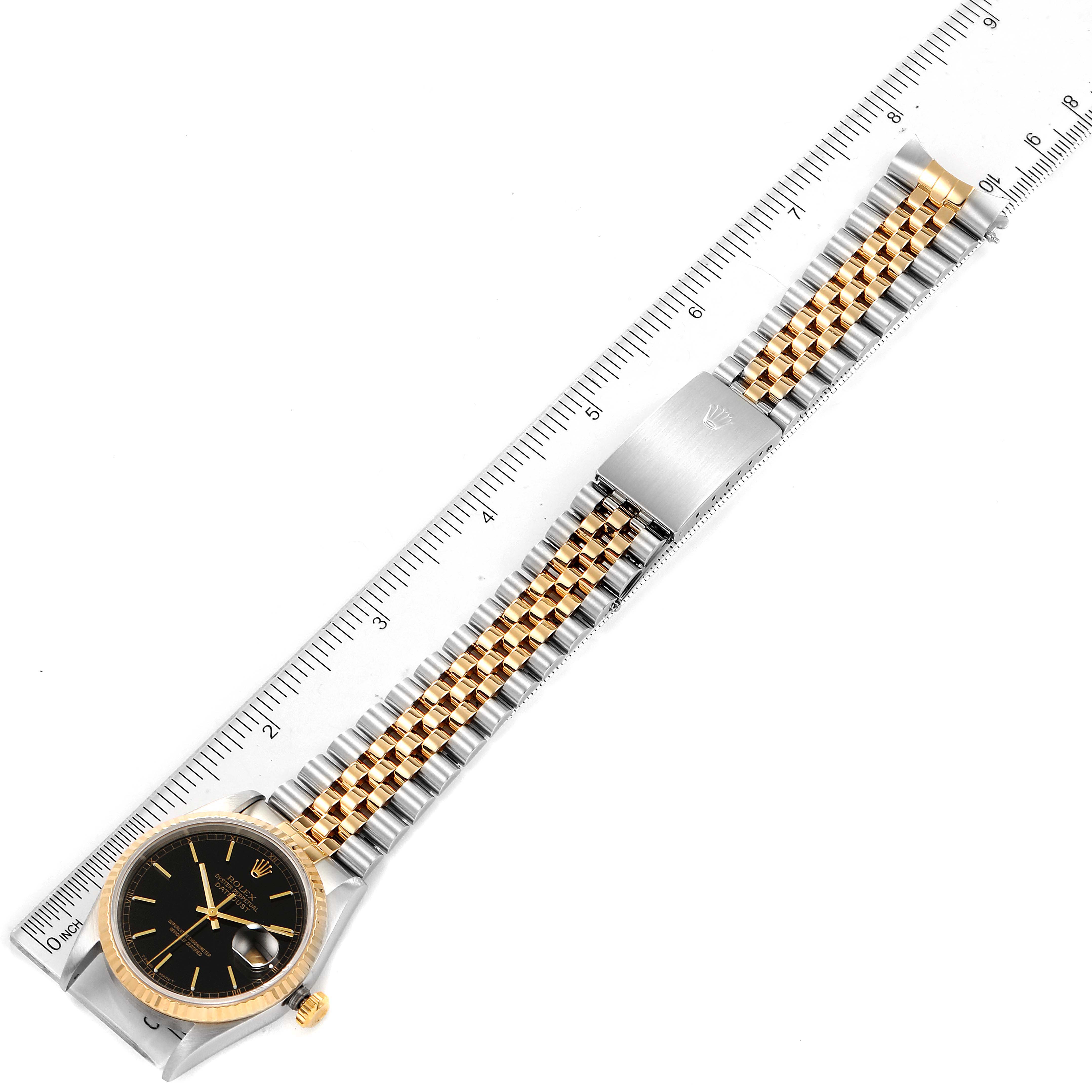 The image shows a Rolex Datejust 16233 Men's Steel and Gold (two tone) Black Dial 16233 Men's Steel and Gold (two tone) Black Dial watch with a two-tone bracelet, displayed alongside a ruler for scale.
