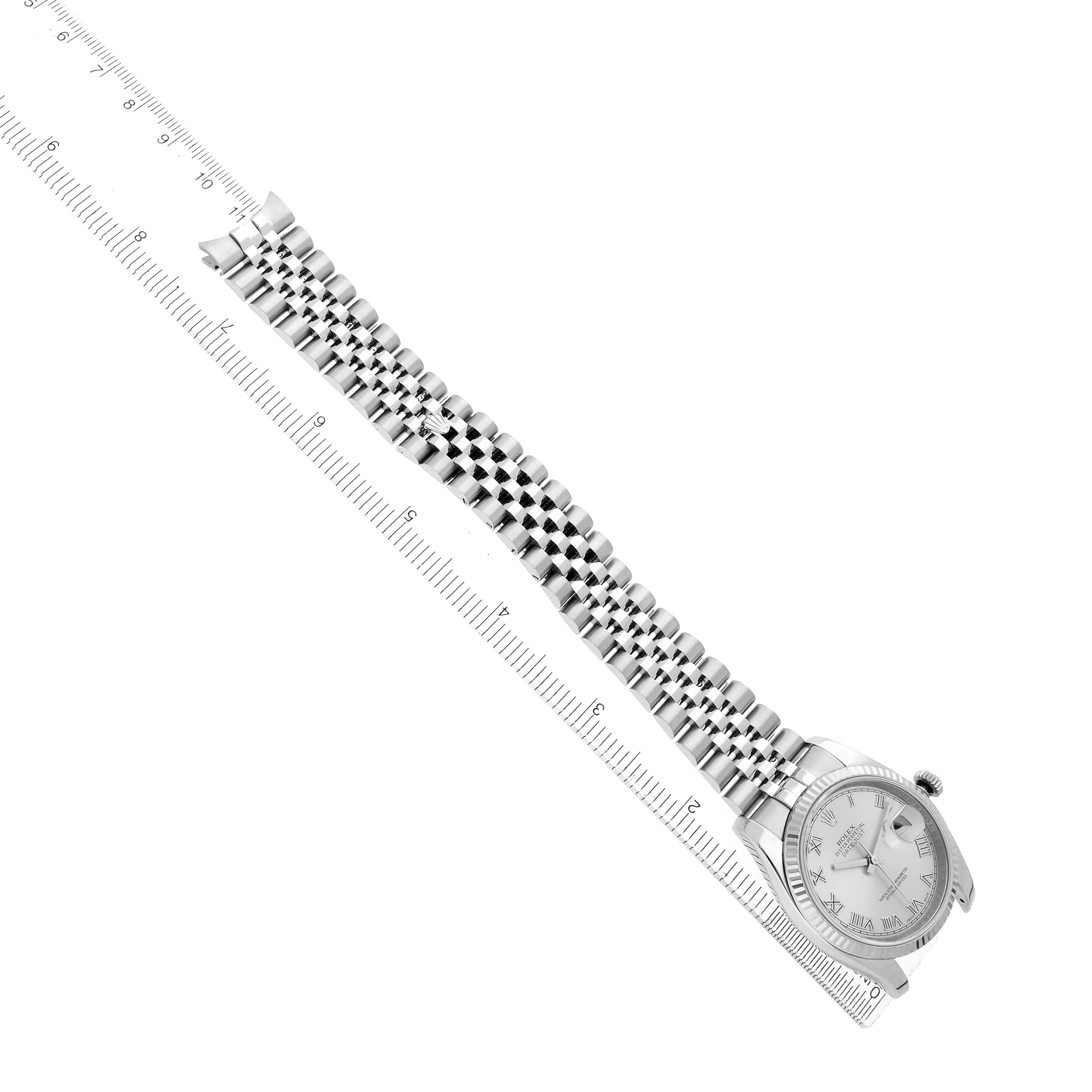 The Rolex Datejust 116234 Men
s Stainless Steel Silver Dial watch is shown at a slightly diagonal angle with focus on the bracelet and face alongside a ruler for scale.