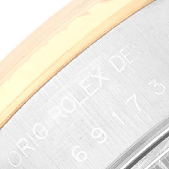 The image shows a close-up of the side of a Rolex Datejust 69173 Women's Steel and Gold (two tone) Blue Dial 69173 Women's Steel and Gold (two tone) Blue Dial watch, highlighting the engraved text and the edge of the case and bezel.