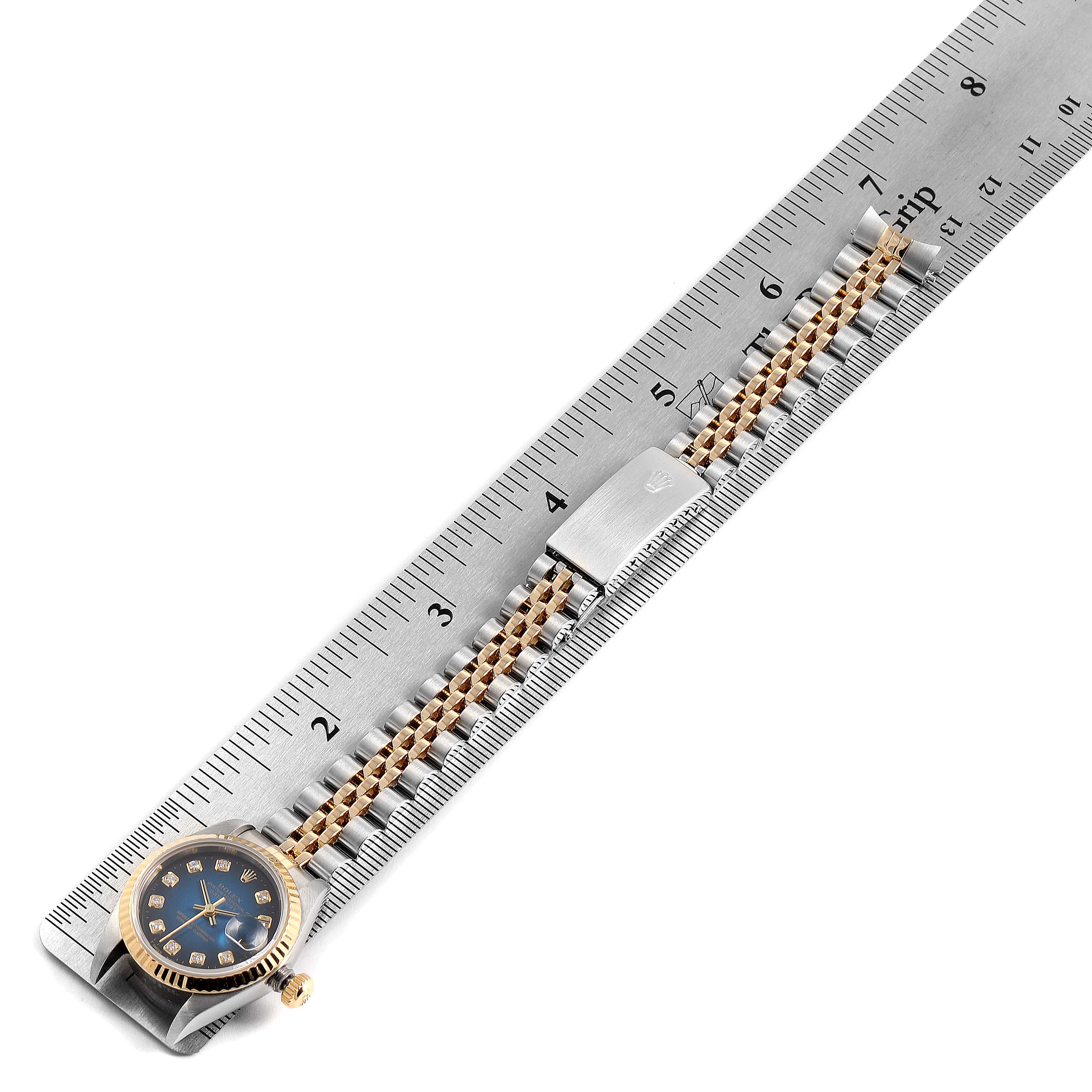 The image shows a Rolex Datejust 79173 Women's Steel and Gold (two tone) Blue Dial 79173 Women's Steel and Gold (two tone) Blue Dial watch laid flat on a ruler, displaying the face and band.