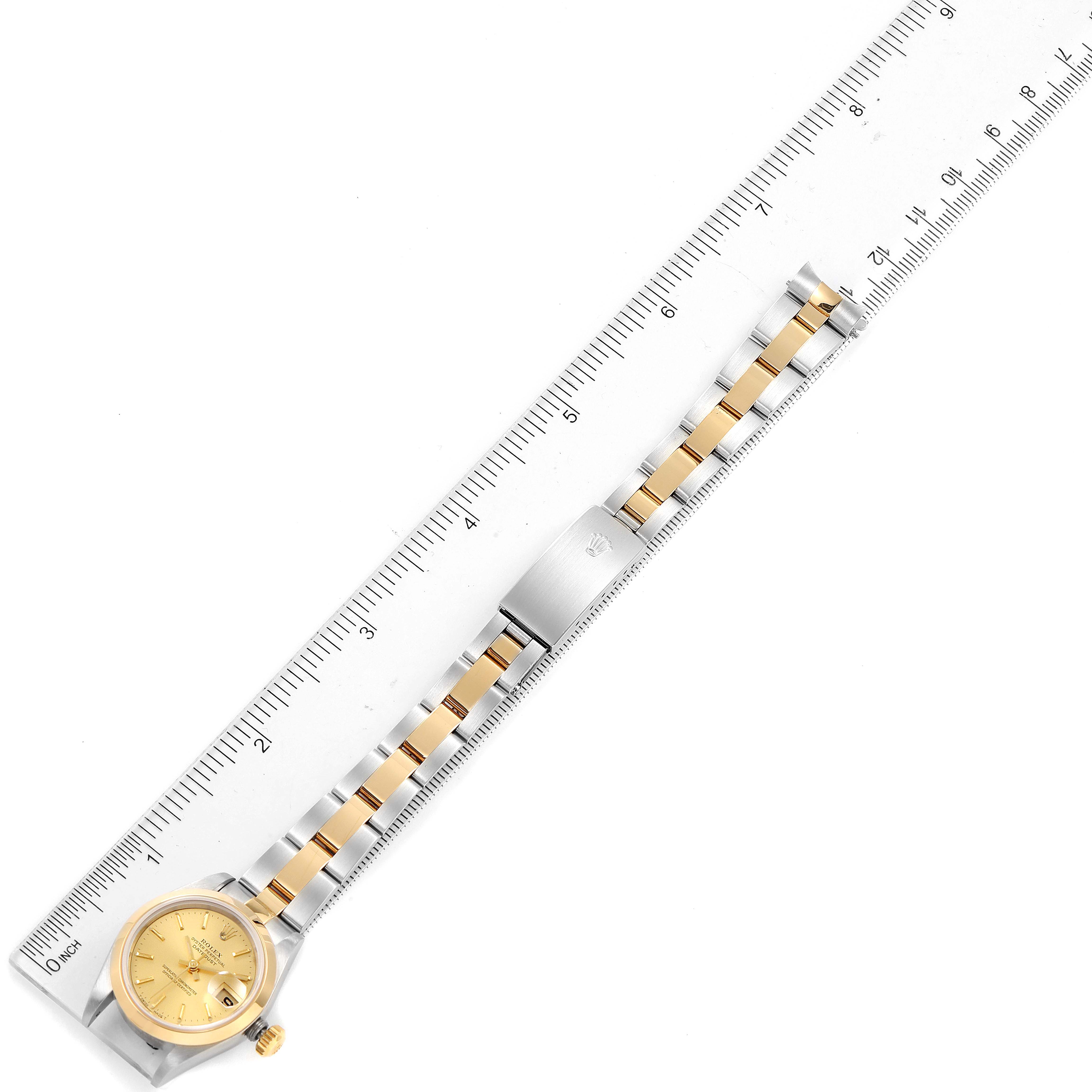 The image displays the full length of the Rolex Datejust 79163 Women's Steel and Gold (two tone) Champagne Dial 79163 Women's Steel and Gold (two tone) Champagne Dial watch, including the face, case, and dual-tone bracelet against a ruler for scale.