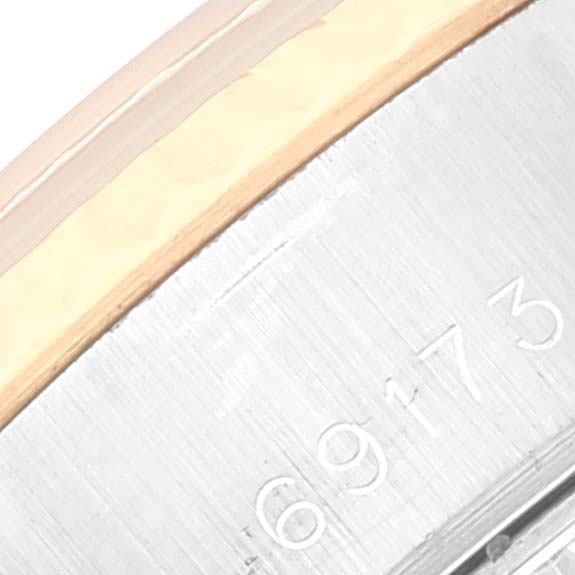 This image shows a close-up of the side of a Rolex Datejust 69173 Women
s Steel and Gold (two tone) Champagne Dial 69173 Women
s Steel and Gold (two tone) Champagne Dial watch, showcasing part of the bezel and serial number engraving.