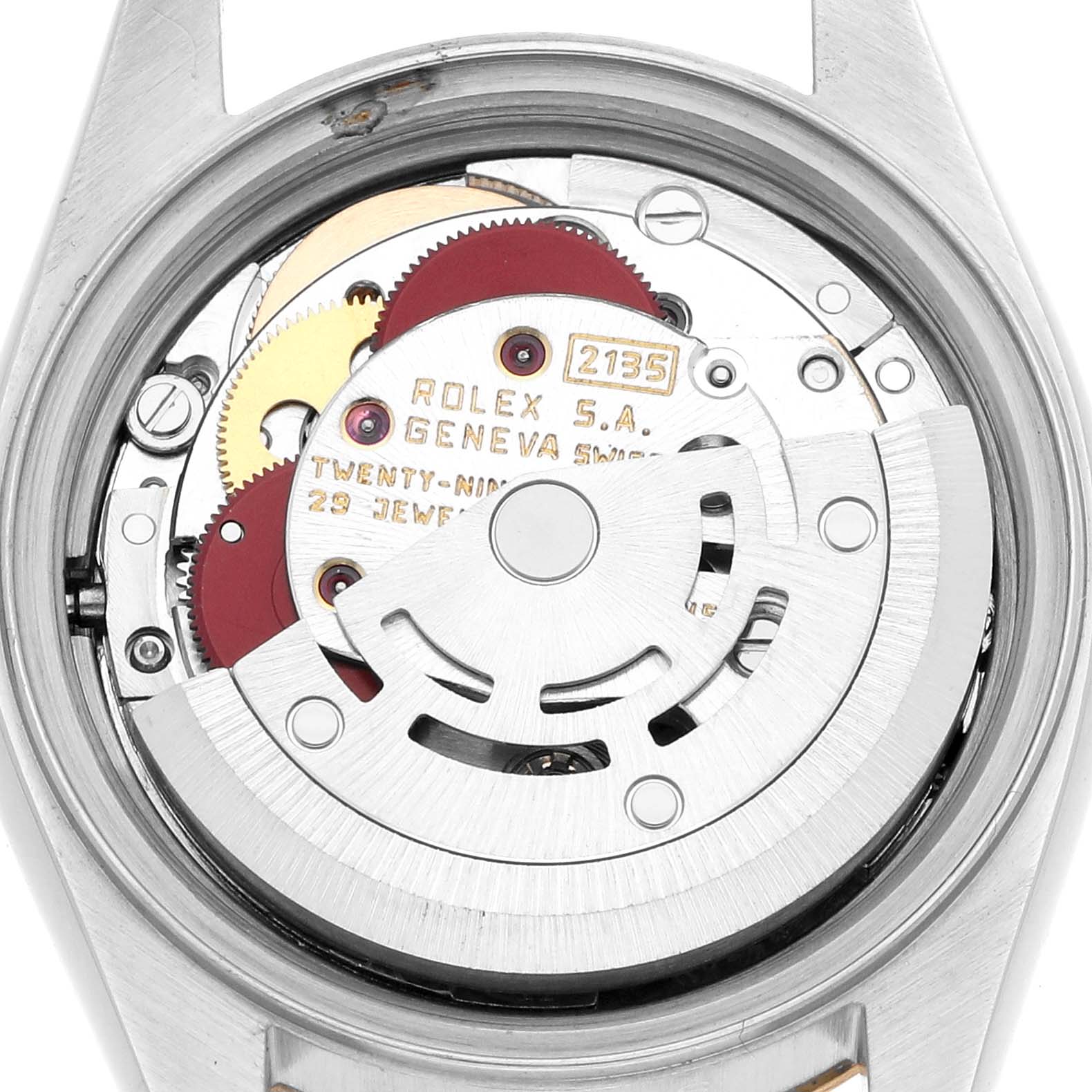 The image shows the movement of a Rolex Datejust 69173 Women
s Steel and Gold (two tone) Champagne Dial, featuring gears, a rotor, and inscribed details from a rear angle.