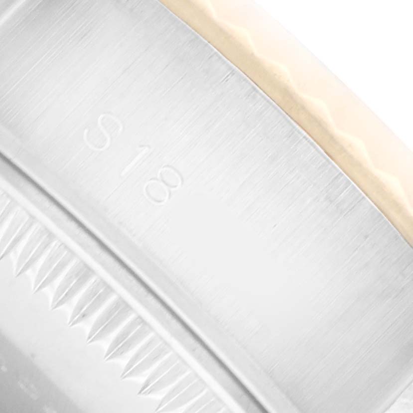 The image shows a close-up of the bezel and edge of a Rolex Datejust 69173 Women
s Steel and Gold (two tone) Champagne Dial watch, highlighting the serrated bezel design.