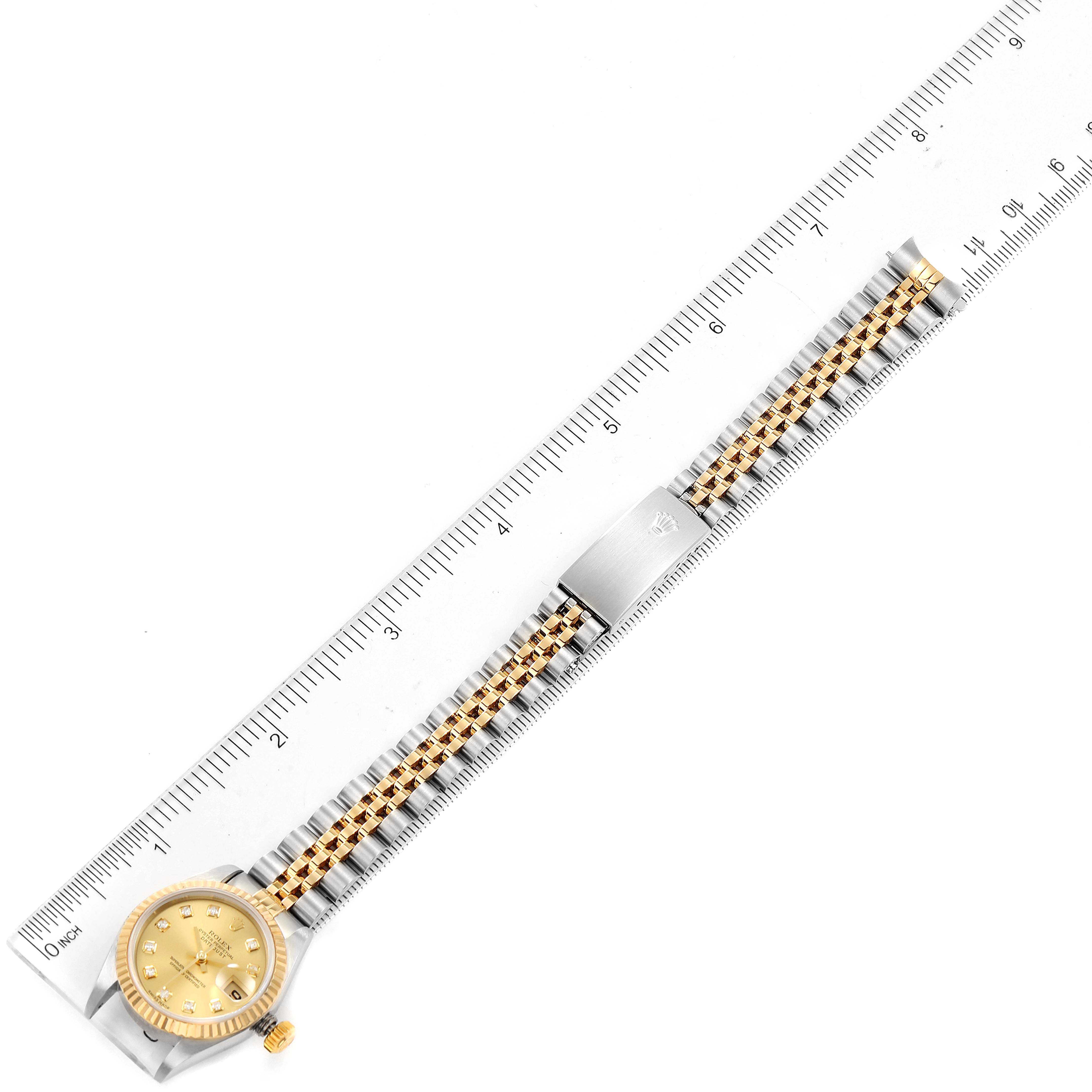 The image shows a Rolex Datejust 79173 Women's Steel and Gold (two tone) Champagne Dial 79173 Women's Steel and Gold (two tone) Champagne Dial watch laid flat with a ruler beside it, displaying the entire bracelet and face.