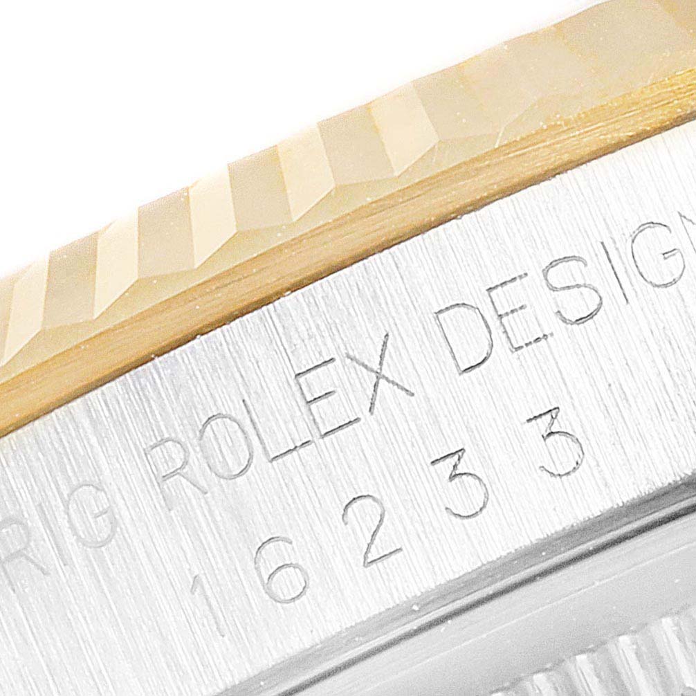 The image shows a close-up of the engraved case side and fluted bezel of a Rolex Datejust 16233 Men's Steel and Gold (two tone) White Dial 16233 Men's Steel and Gold (two tone) White Dial model.