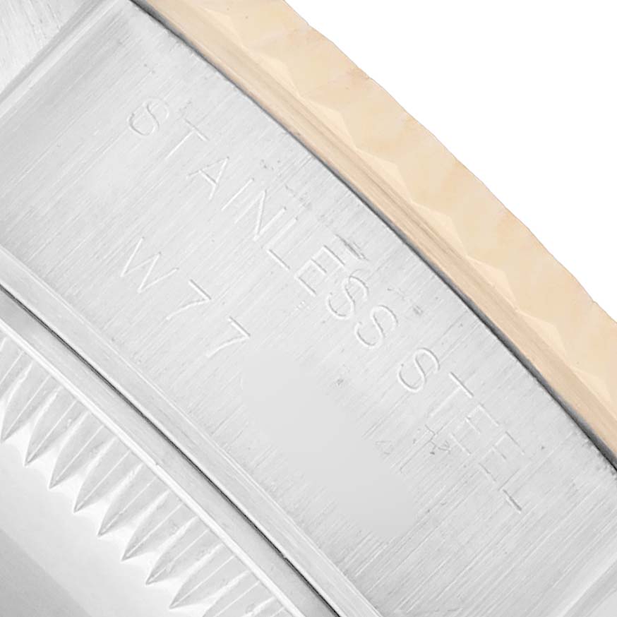 The image shows a close-up of the side of a Rolex Datejust 69173 Women
s Steel and Gold (two tone) White Dial, highlighting the stainless steel and textured edge.