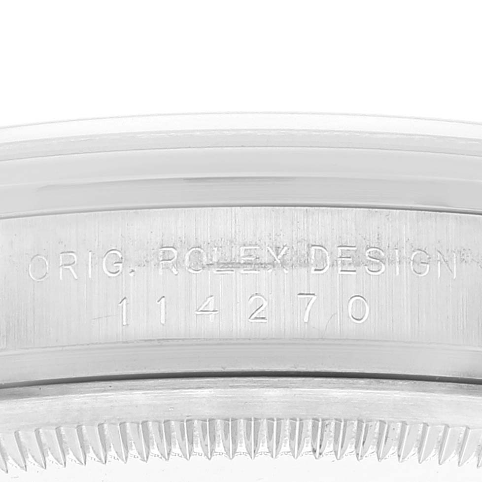 This image shows a close-up of the engraved serial number on the side of a Rolex Explorer 114270 Men's Stainless Steel Black Dial 114270 Men's Stainless Steel Black Dial model.