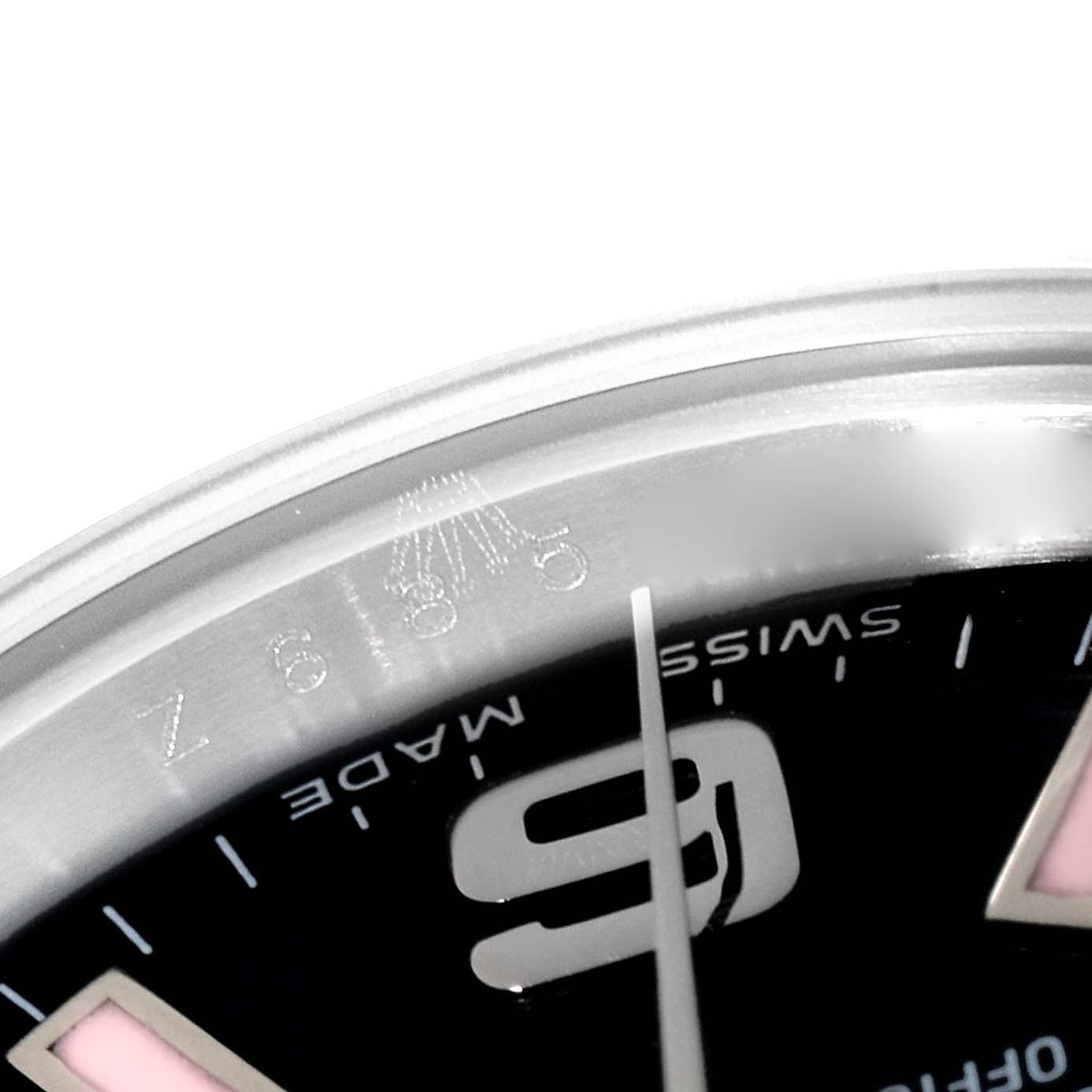 This close-up of a Rolex Oyster Perpetual 176200 Women's Stainless Steel Black Dial 176200 Women's Stainless Steel Black Dial watch shows part of the dial and the edge of the case near the "9" numeral.