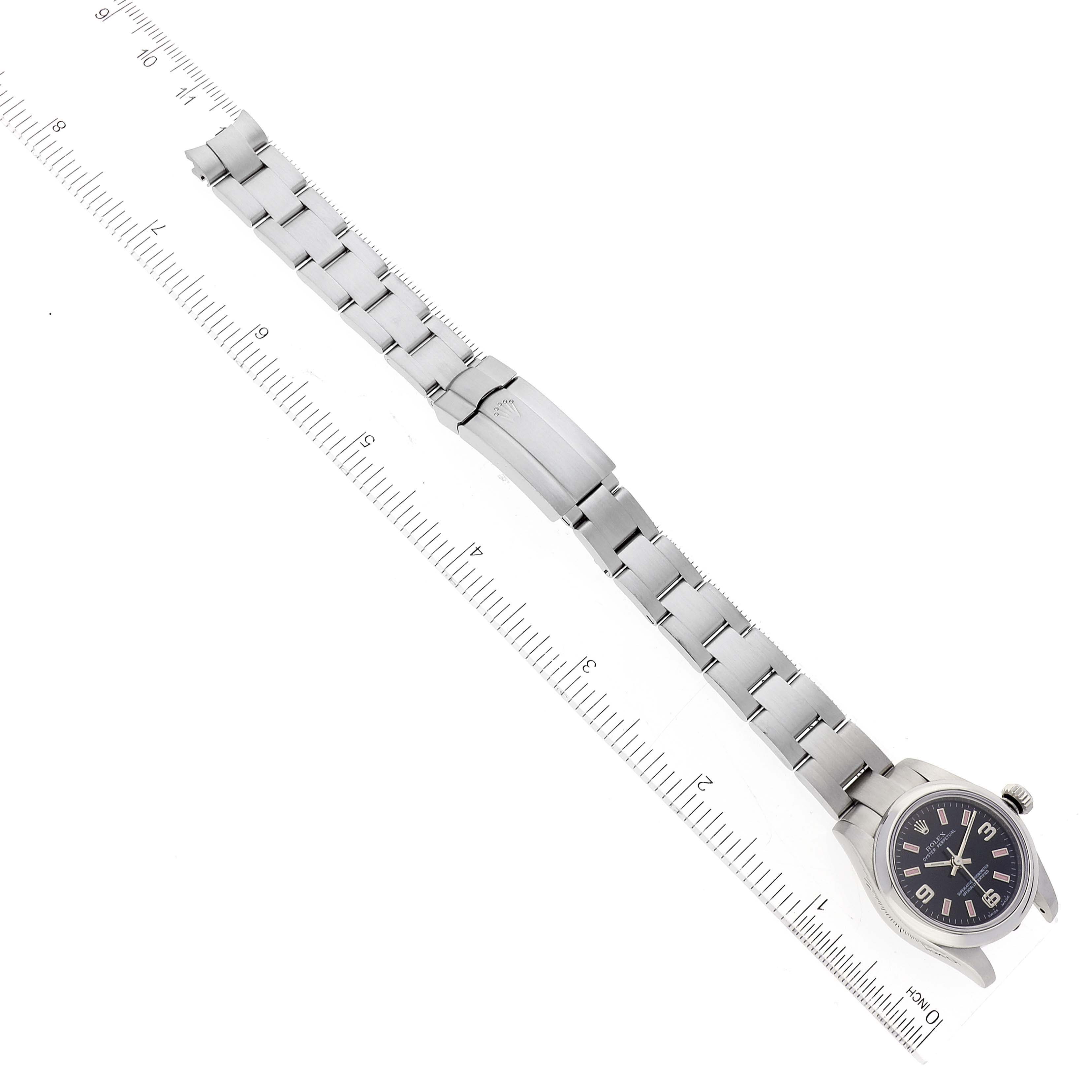 A top-down view of a Rolex Oyster Perpetual 176200 Women's Stainless Steel Black Dial 176200 Women's Stainless Steel Black Dial watch, displaying the bracelet, clasp, and face next to a ruler.