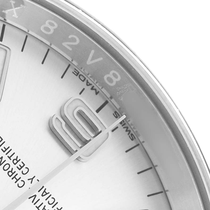 The image shows a partial close-up of a Rolex Oyster Perpetual 116000 Men
s Stainless Steel Silver Dial watch face, focusing on the indices and a portion of the dial.