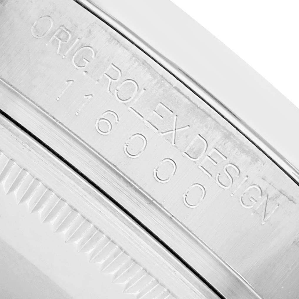 The image displays the model number and design engraving on the side of a Rolex Oyster Perpetual 116000 Men
s Stainless Steel Silver Dial watch
s case.