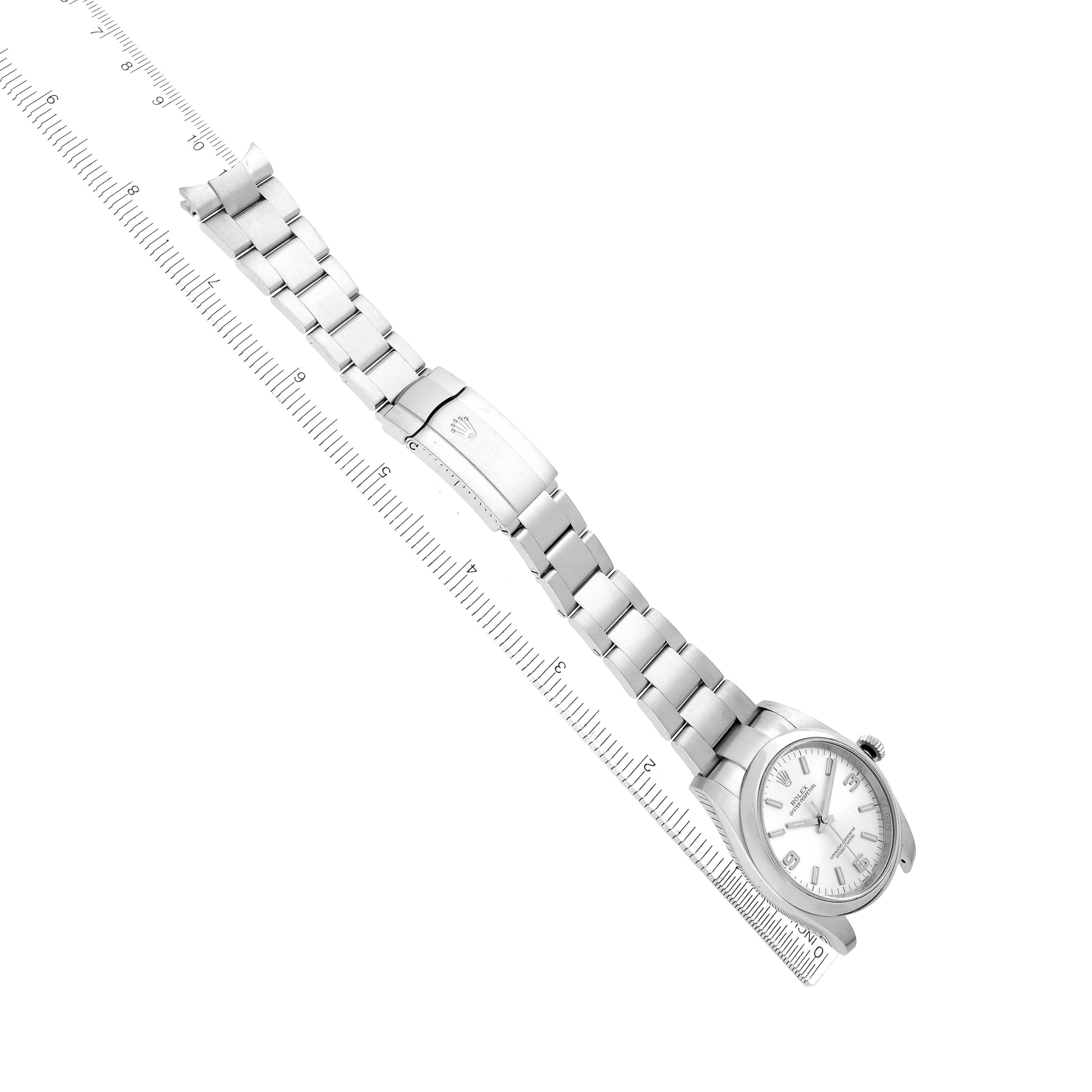 The Rolex Oyster Perpetual 116000 Men
s Stainless Steel Silver Dial watch is shown diagonally, highlighting its band, clasp, and case, with a ruler underneath.