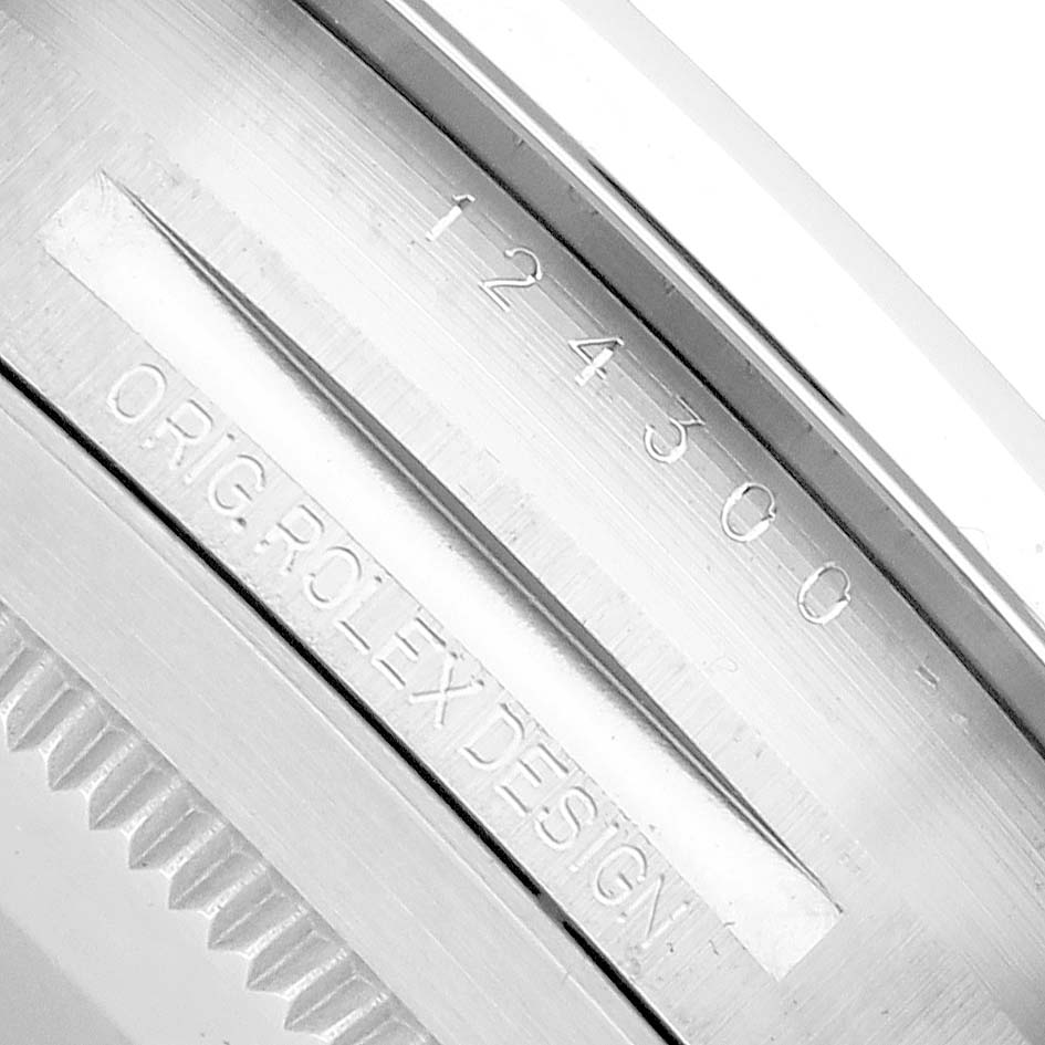 The image shows a close-up of the side of a Rolex Oyster Perpetual 124300 Men
s Stainless Steel Silver Dial watch case, featuring the engraved serial and design numbers.
