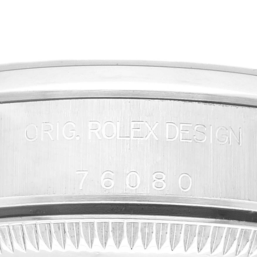 This image shows a close-up of the case back of a Rolex Oyster Perpetual 76080 Women
s Stainless Steel Blue Dial 76080 Women
s Stainless Steel Blue Dial watch, displaying the model number 76080 and "ORIG. ROLEX DESIGN" engraving.