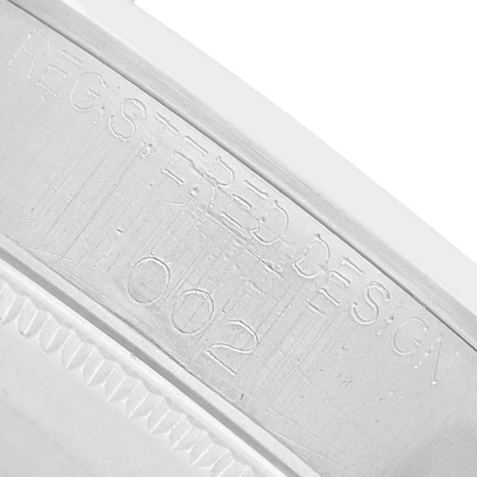The image shows a close-up of the engraving on the metal part of a Rolex Oyster Perpetual 1002 Men
s Stainless Steel White Dial watch, featuring the phrase "REGISTERED DESIGN."