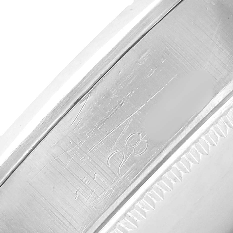 The image shows a close-up of the engraving on the casing or bezel side of a Rolex Oyster Perpetual 1002 Men
s Stainless Steel White Dial watch.