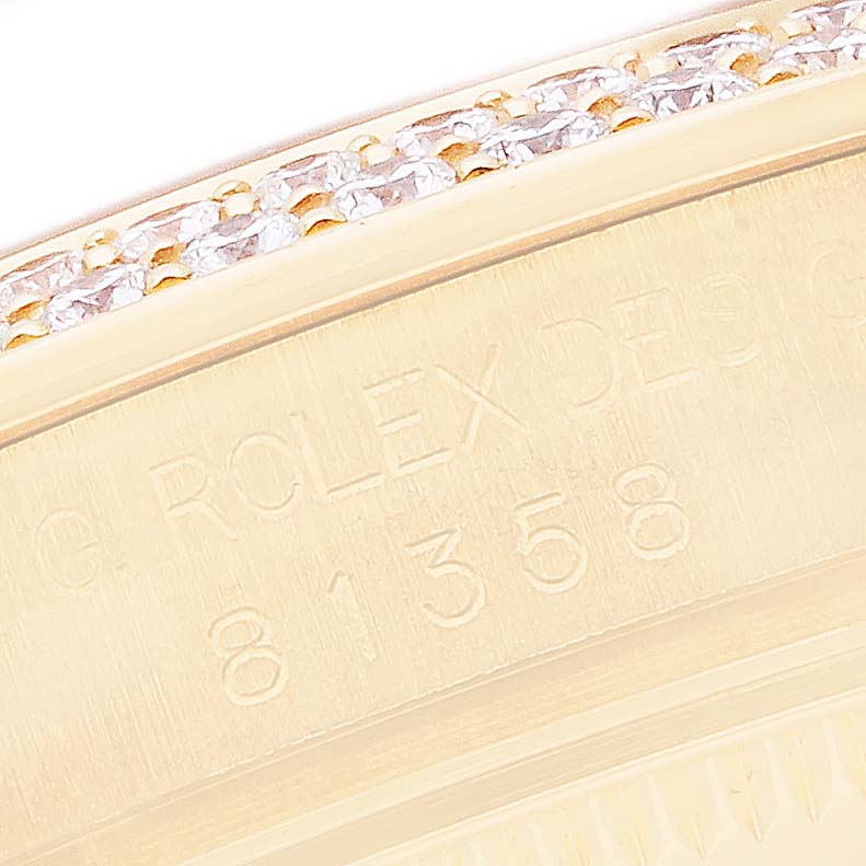 The image shows a close-up of the Rolex Pearlmaster 81358 Women
s Yellow Gold Mother of Pearl Dial bezel with engravings and a row of diamonds.