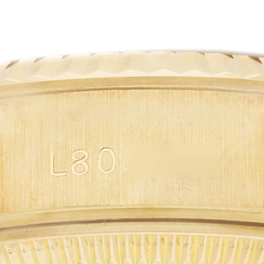 The image shows an angled close-up of the case back edge of a Rolex President 69178 Women
s Yellow Gold White Dial watch with engravings visible.
