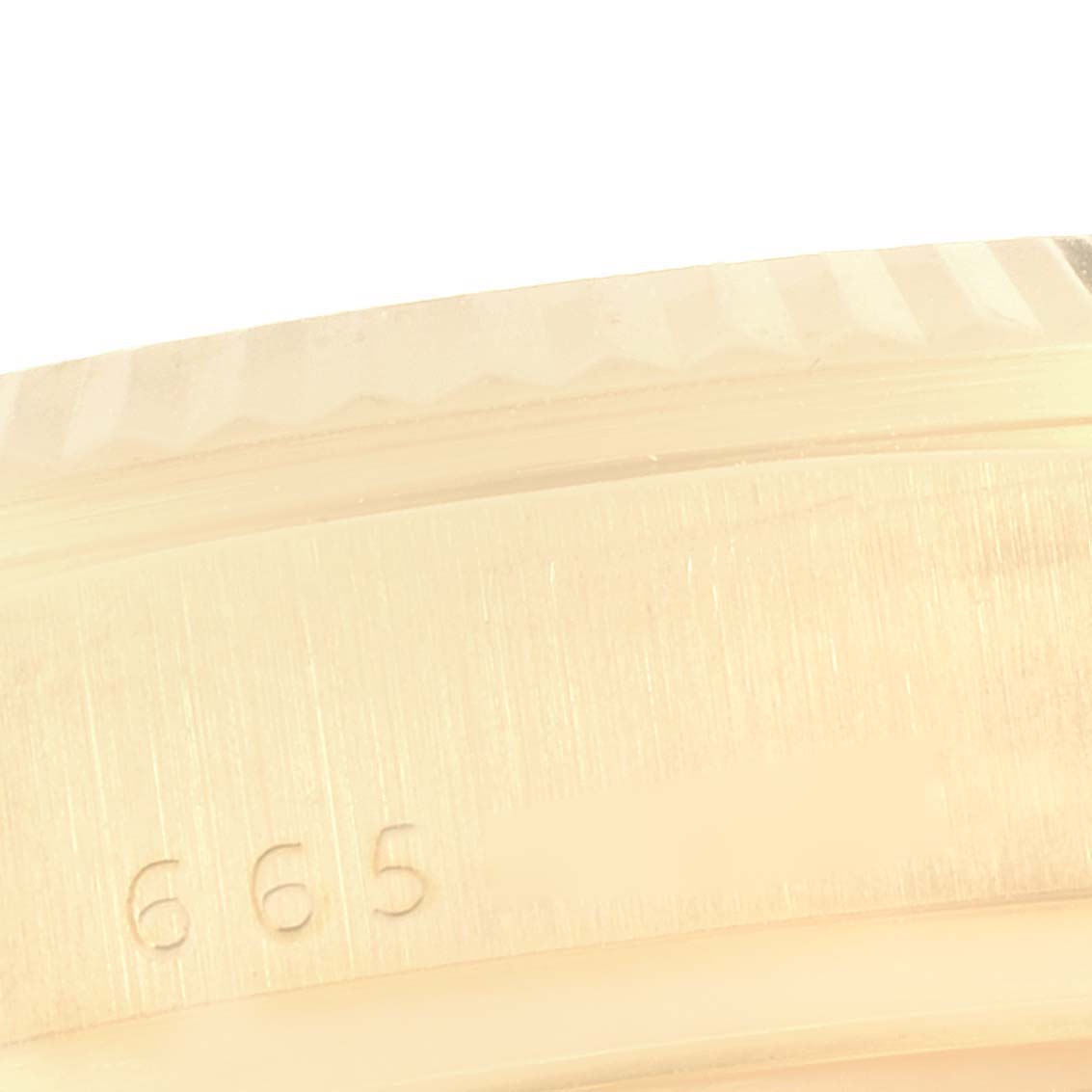 This close-up image of the Rolex President 18038 Men's Yellow Gold White Dial 18038 Men's Yellow Gold White Dial model showcases a portion of its case, highlighting its textured bezel and engraved numbers.