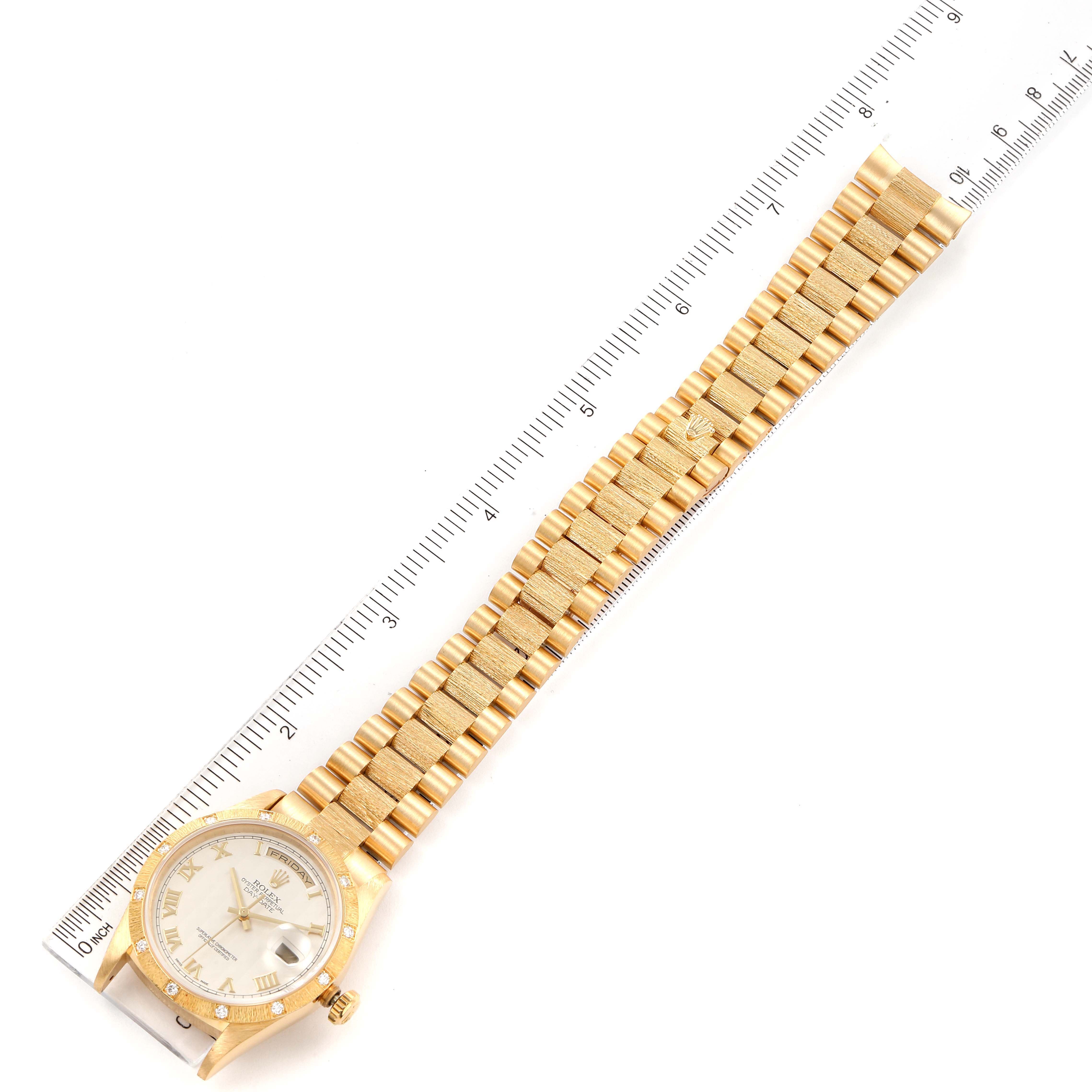 The Rolex President 18308 Men's Yellow Gold Beige Dial 18308 Men's Yellow Gold Beige Dial model watch is shown from a top-down angle, displaying its face, bezel, and full bracelet with a ruler beside it.