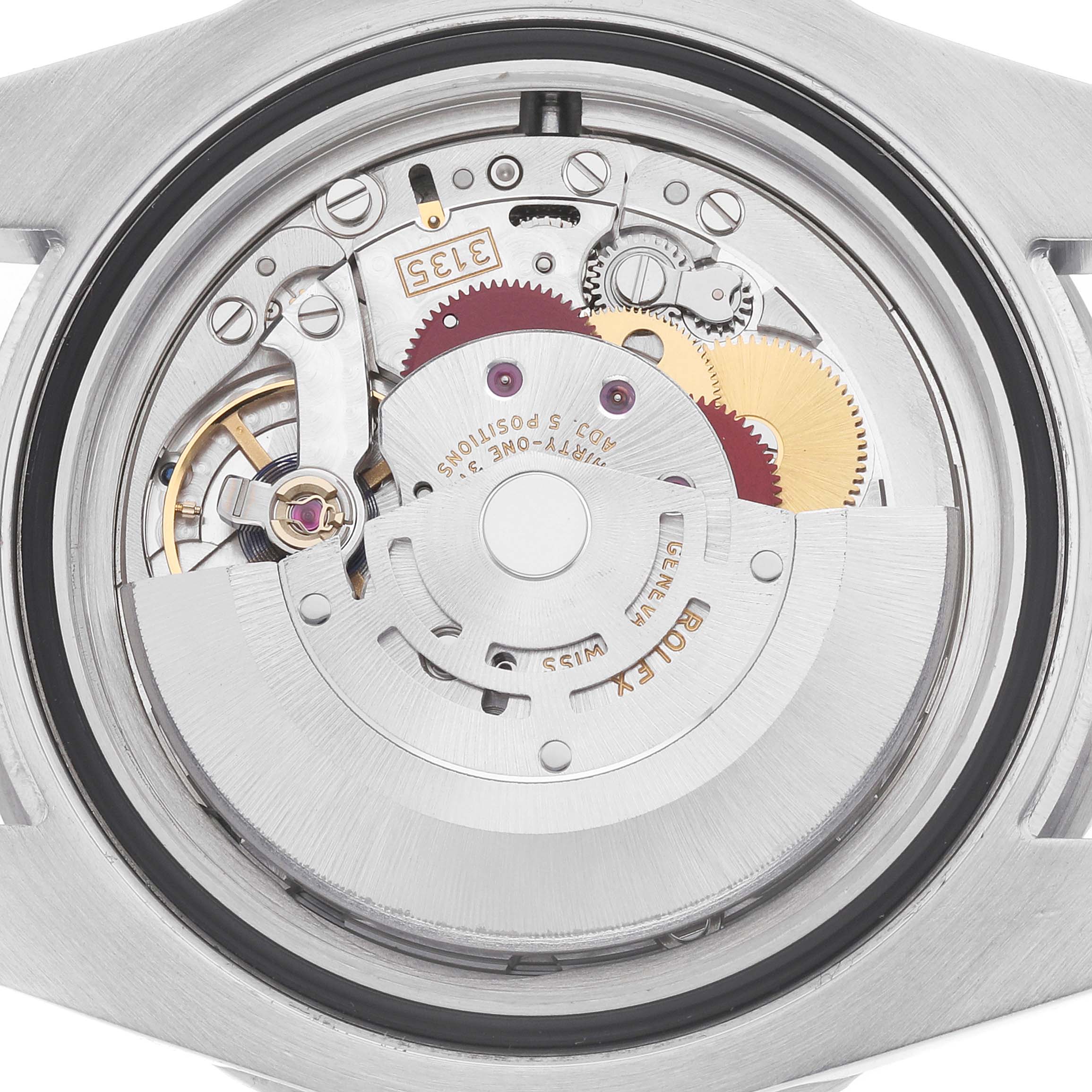 The image shows the movement mechanism of a Rolex Submariner 116610LV Men
s Stainless Steel Green Dial watch from a rear angle, highlighting gears and components.