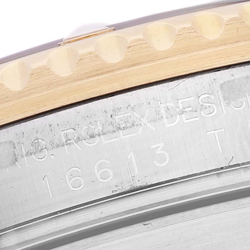 This image shows a close-up of the engraved casing and bezel of a Rolex Submariner 16613 Men's Steel and Gold (two tone) Champagne Dial 16613 Men's Steel and Gold (two tone) Champagne Dial watch.