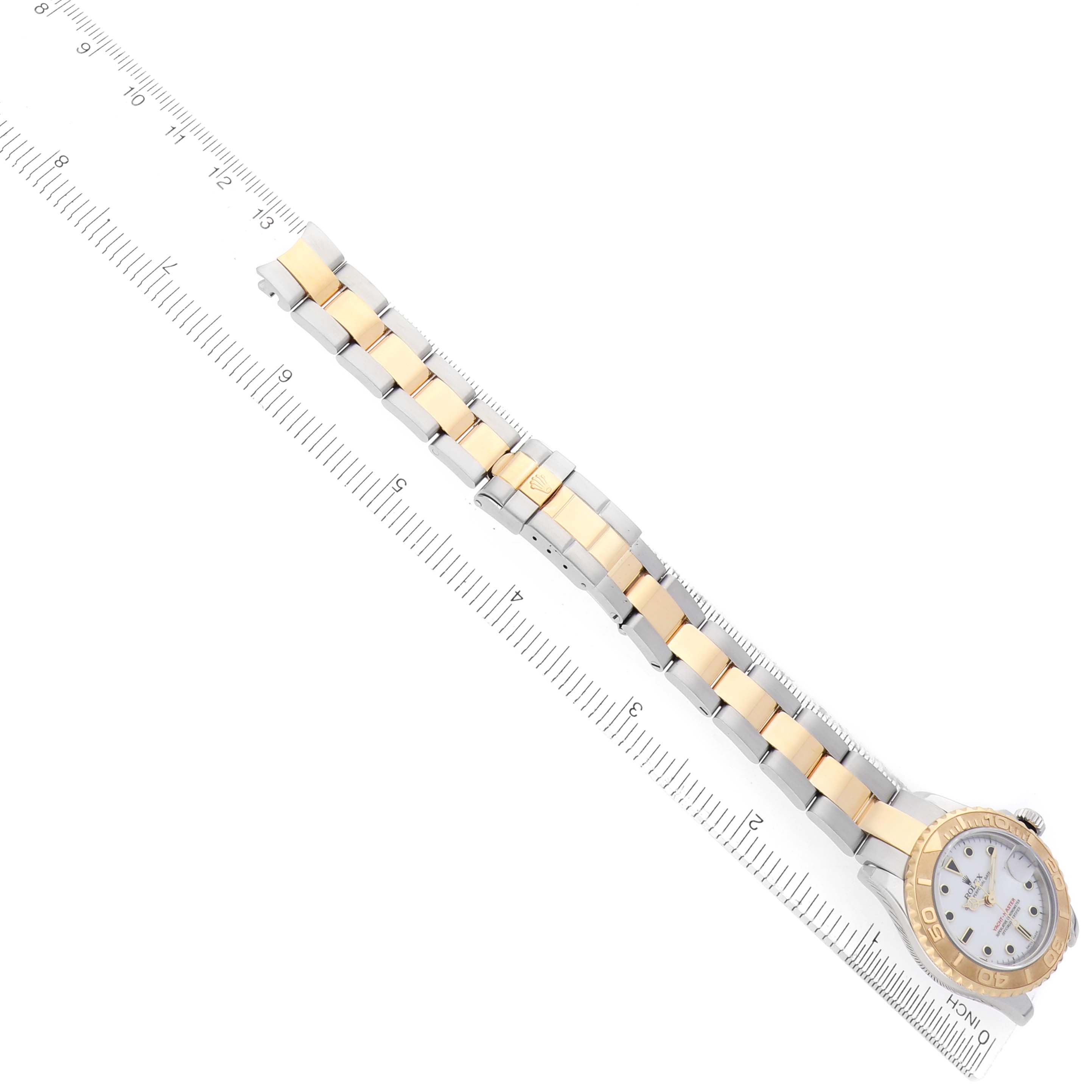 The Rolex Yacht-Master 169623 Women
s Steel and Gold (two tone) White Dial watch is shown at an angle emphasizing the face, bezel, and bracelet, aligned with a ruler.