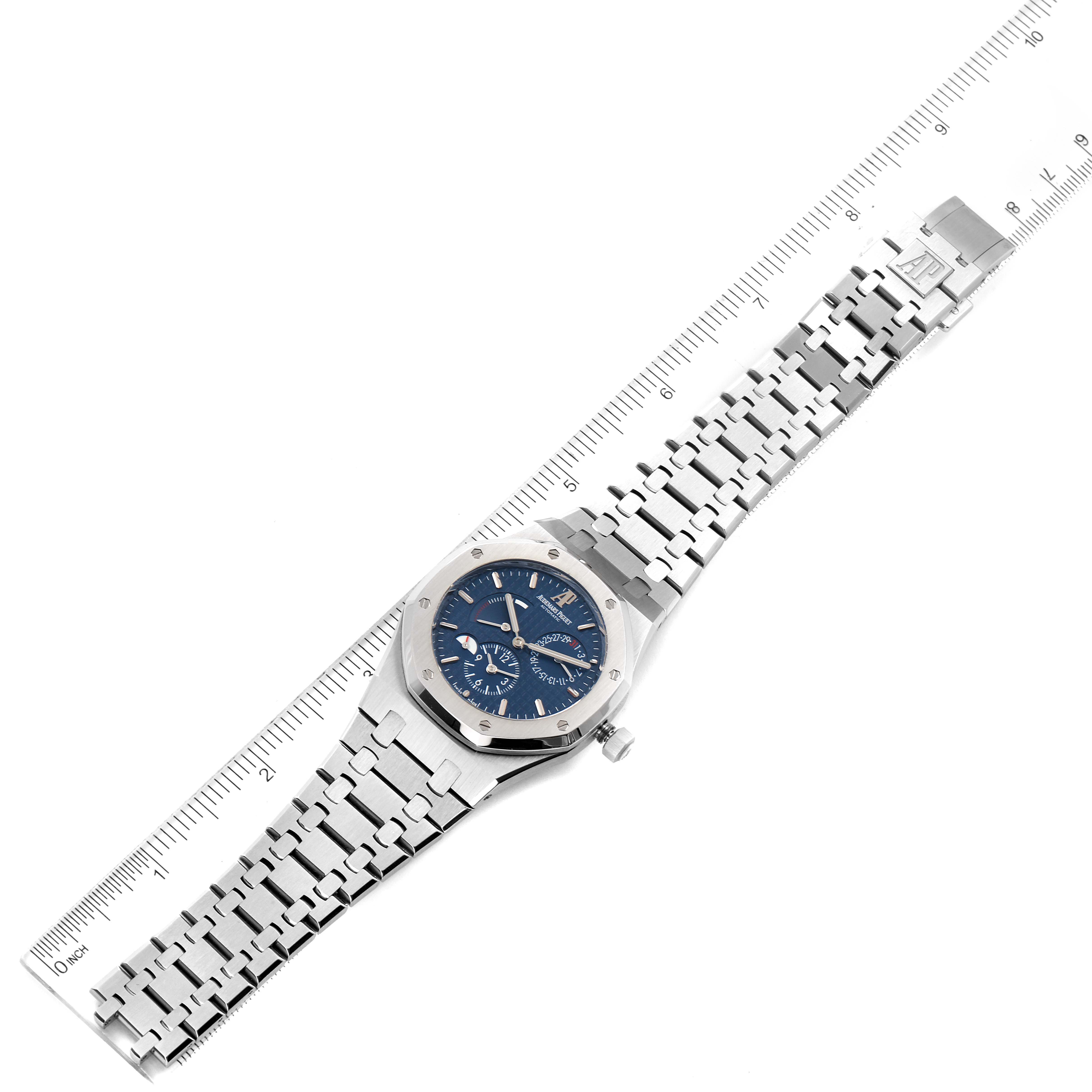 The image shows a top-down view of an Audemars Piguet Royal Oak 26120ST.00.1220ST.02 Men's Stainless Steel Blue Dial 26120ST.00.1220ST.02 Men's Stainless Steel Blue Dial watch with its bracelet fully extended near a ruler.