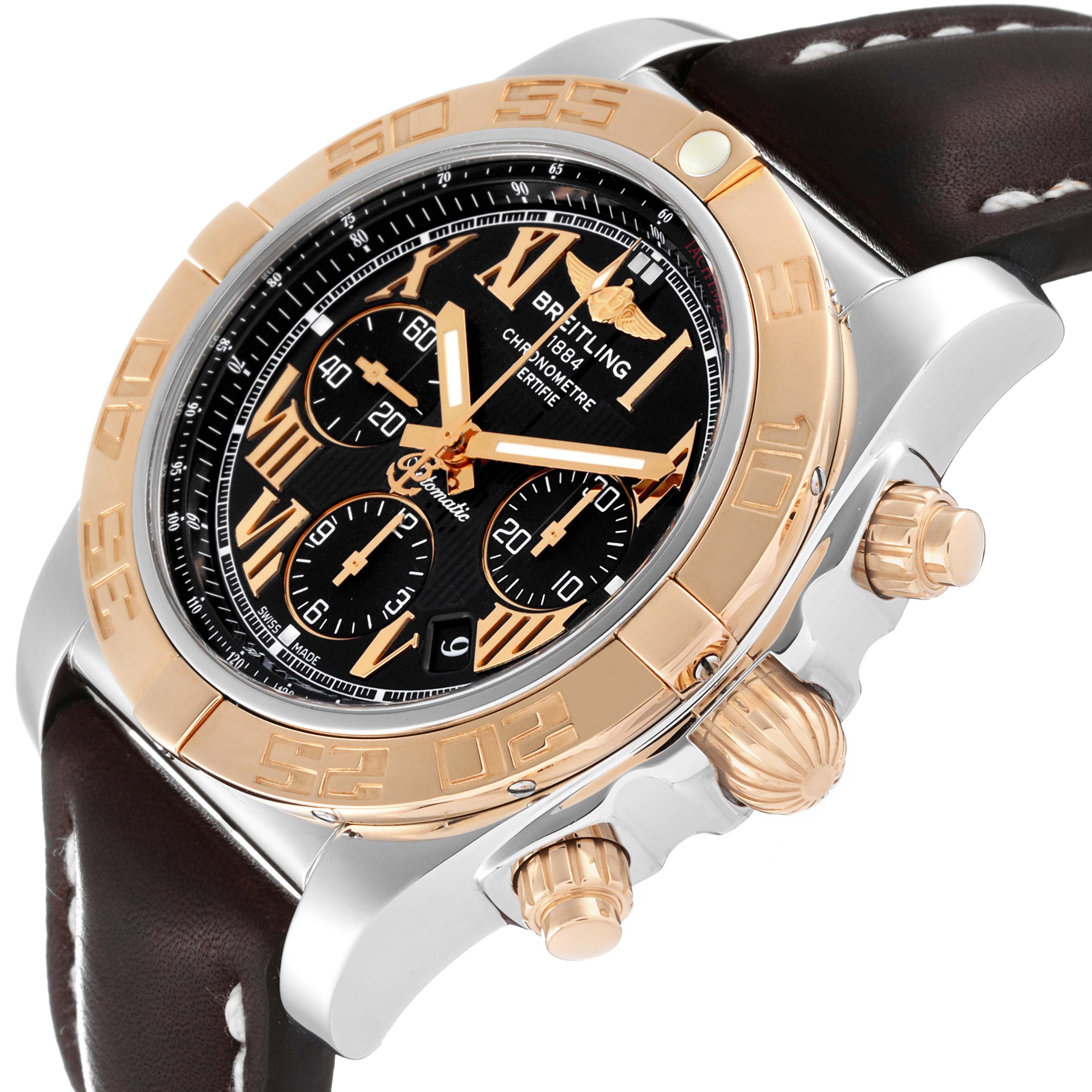 The Breitling Chronomat CB0110 Men's Steel and Gold (two tone) Black Dial CB0110 Men's Steel and Gold (two tone) Black Dial watch is shown at an angle highlighting the dial, bezel, crown, and pushers with a leather strap.