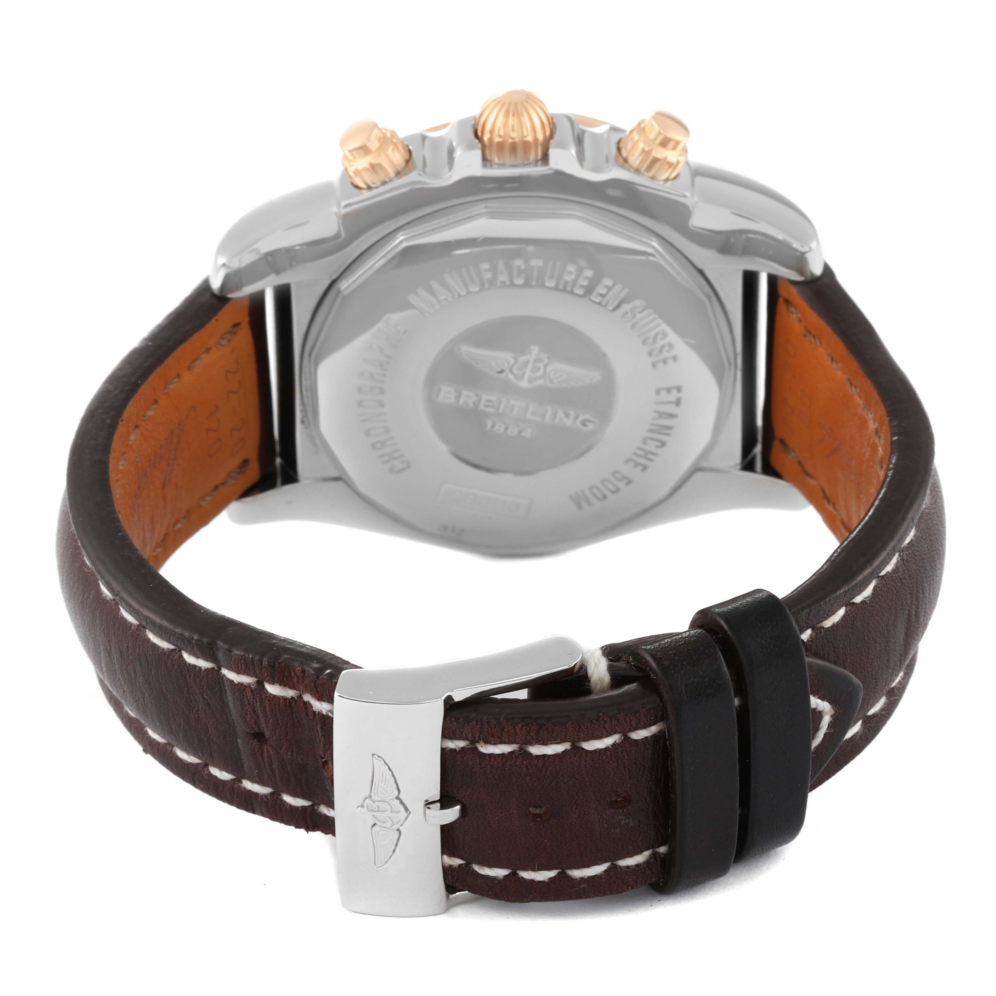 The image shows the back view of a Breitling Chronomat CB0110 Men's Steel and Gold (two tone) Black Dial CB0110 Men's Steel and Gold (two tone) Black Dial watch, displaying its case back, leather strap, and clasp.
