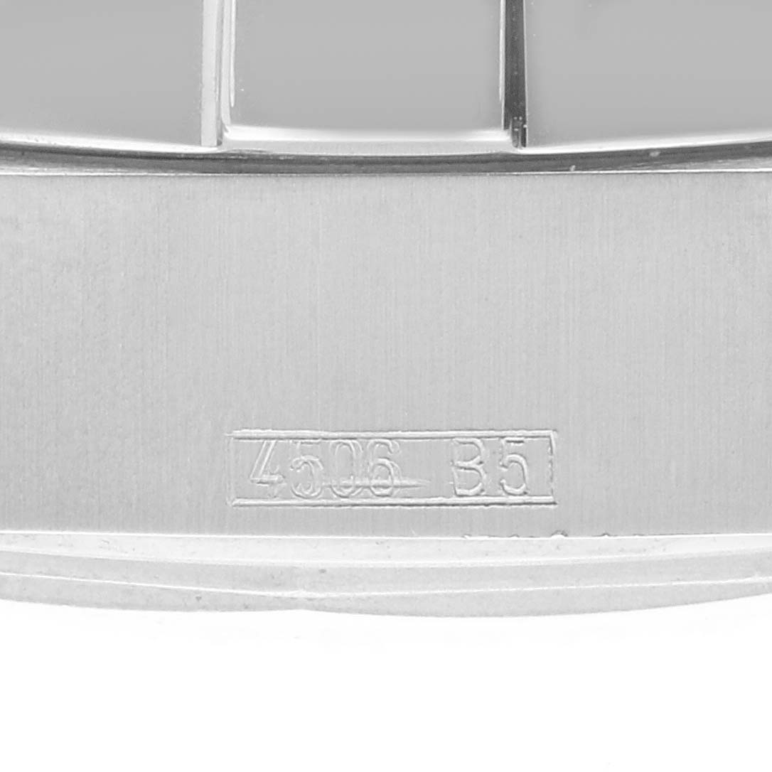 This image shows a macro shot of the metal casing of the Breitling Superocean A17390 Men's Stainless Steel Blue Dial A17390 Men's Stainless Steel Blue Dial watch with a serial number visible.