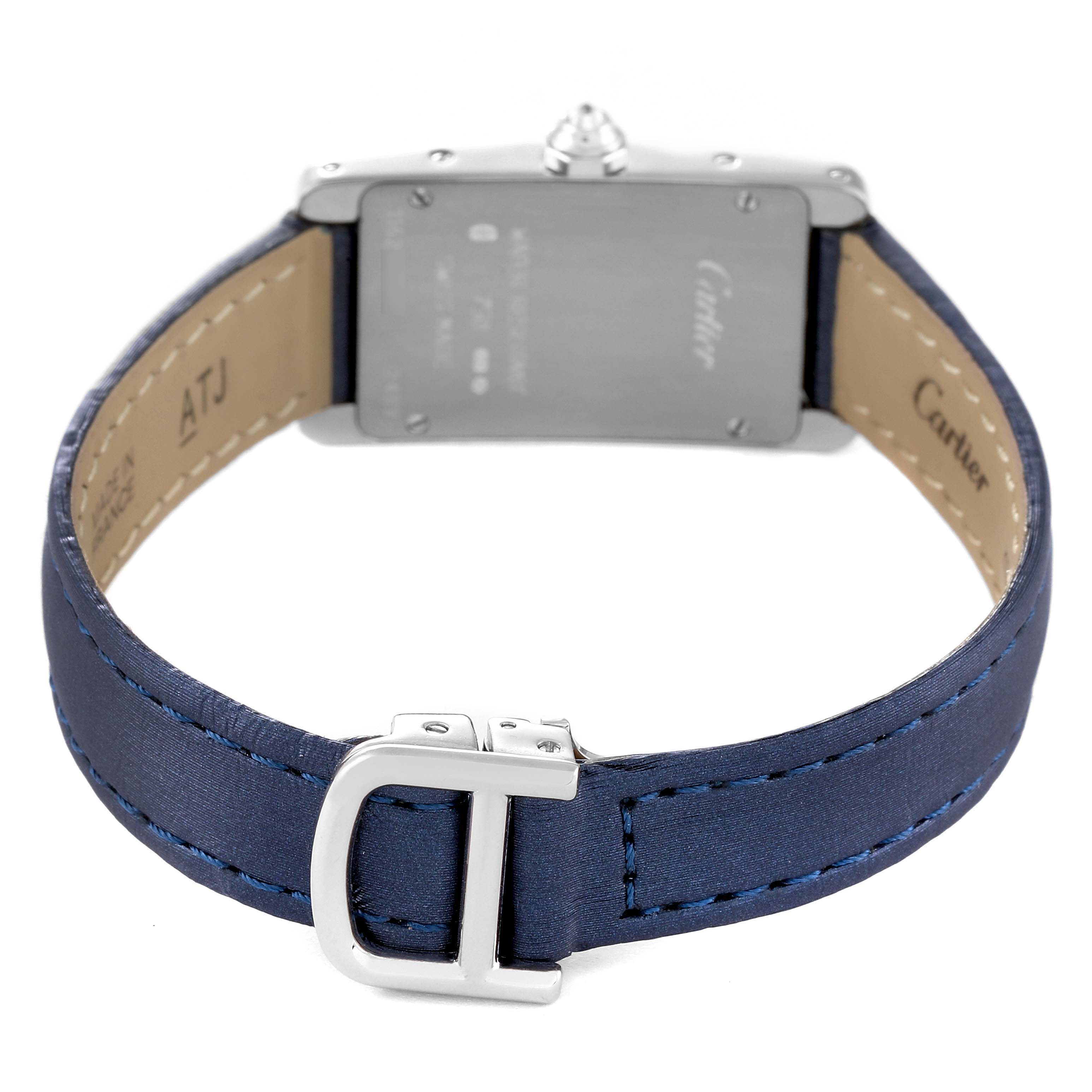 This image shows the back view of a Tank Americaine by Cartier, highlighting its case back and blue leather strap with a buckle.