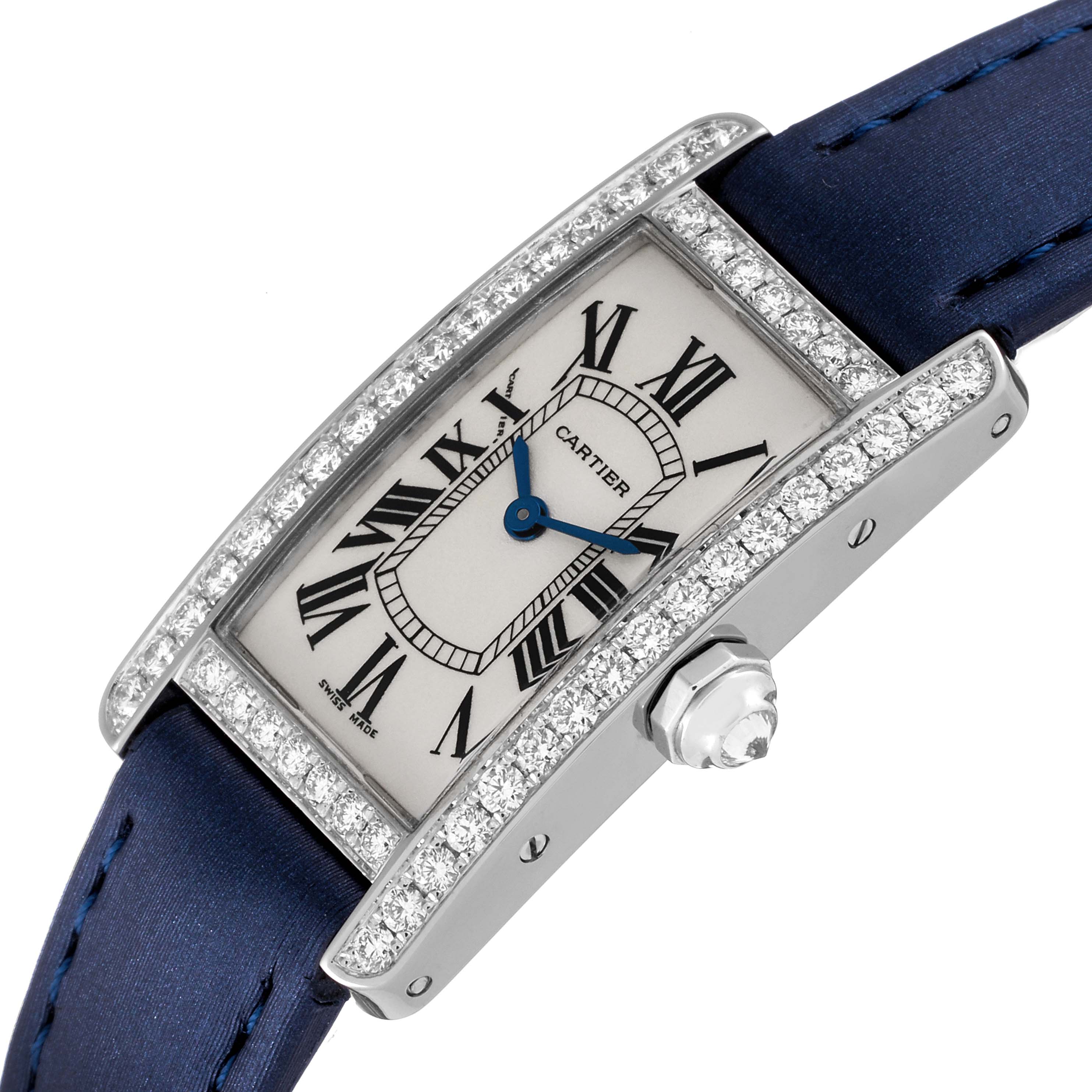 The image shows a Cartier Tank Americaine WB7018L1 Women's White Gold Silver Dial WB7018L1 Women's White Gold Silver Dial watch at an angle highlighting its diamond-encrusted bezel and blue strap.