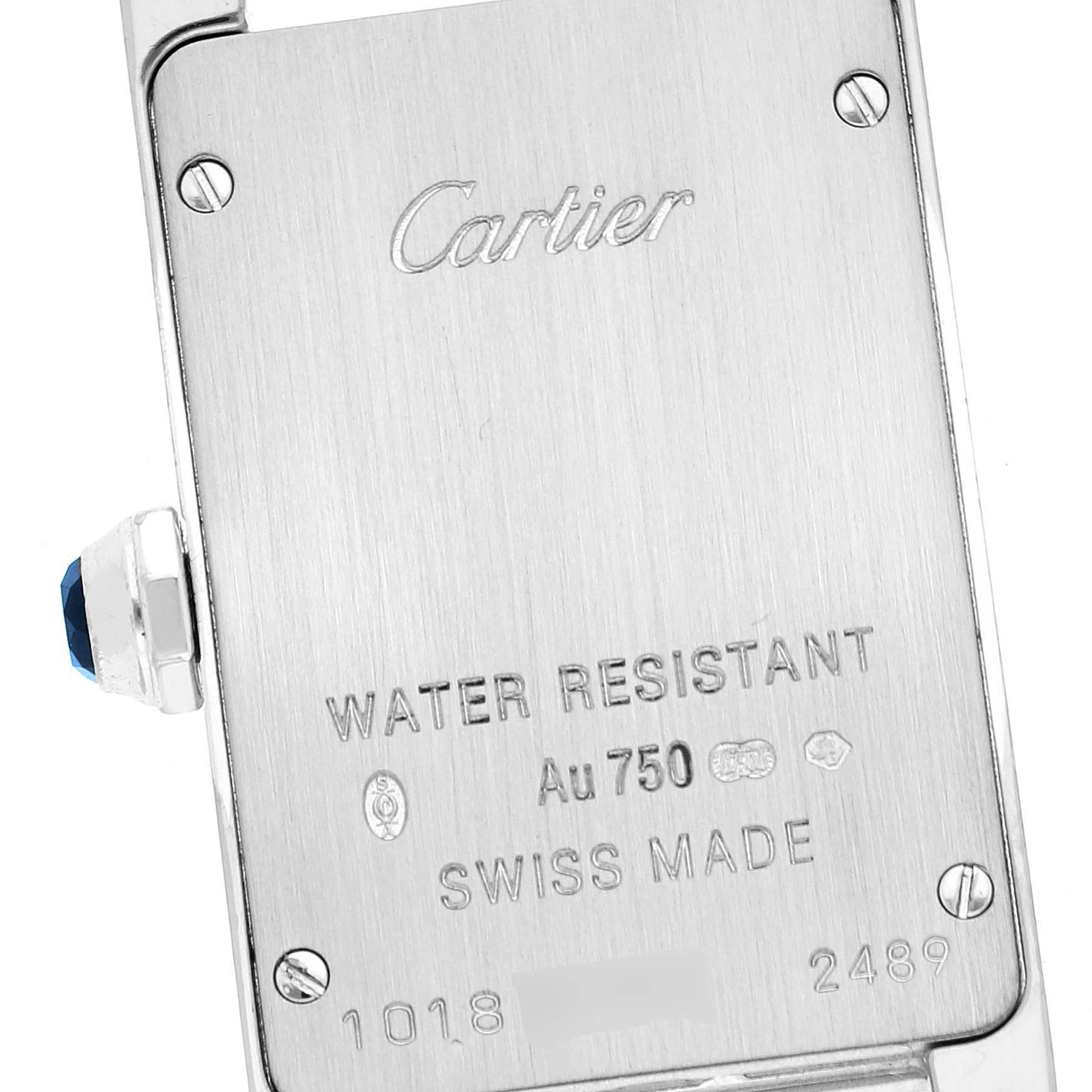 The image shows the back case of a Cartier Tank Americaine W2601956 Women's White Gold Silver Dial W2601956 Women's White Gold Silver Dial watch, highlighting details like the brand name, water resistance, and serial numbers.