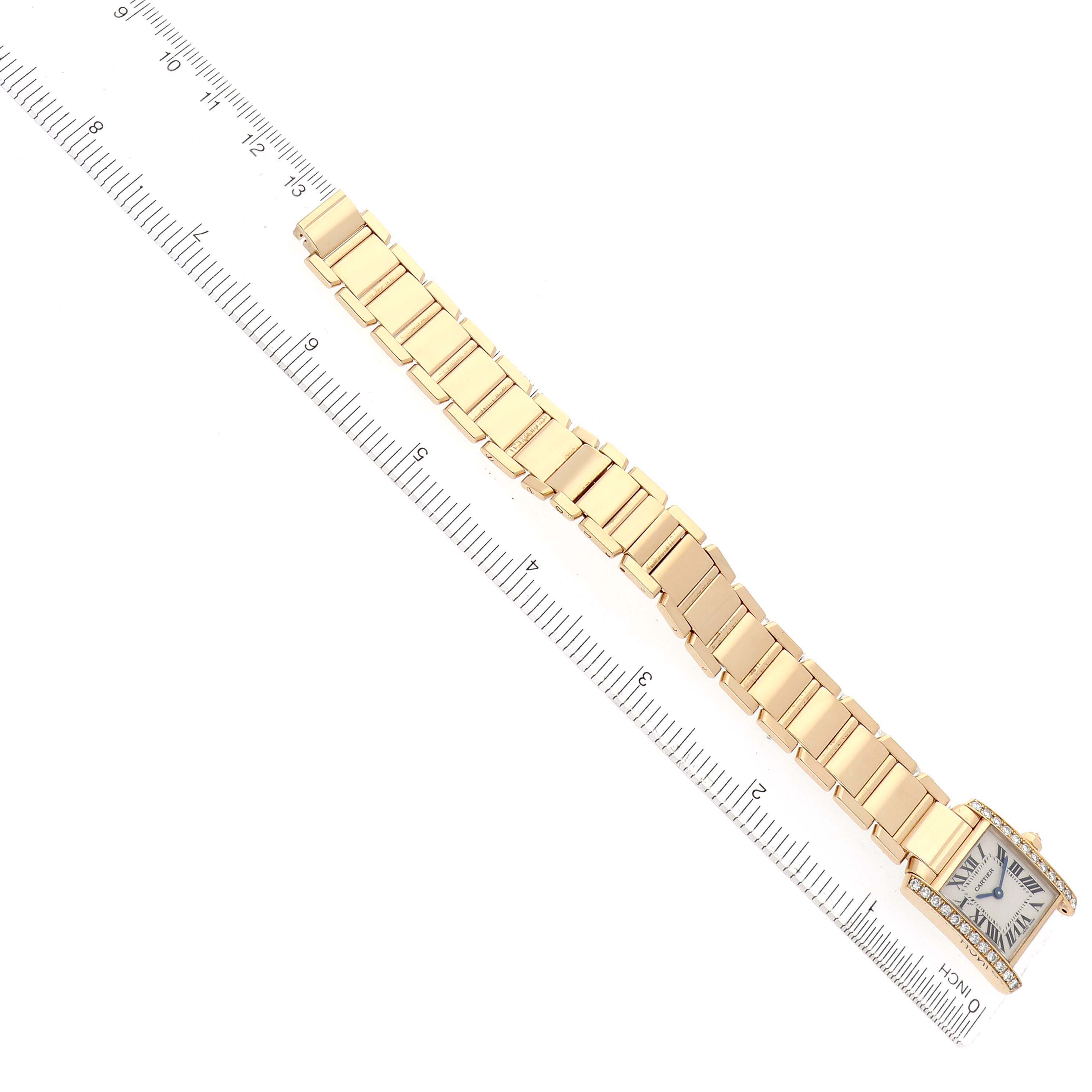 The Cartier Tank Francaise WE1001R8 Women
s Yellow Gold Silver Dial watch is shown flat, displaying the full bracelet length and square face beside a ruler for scale.
